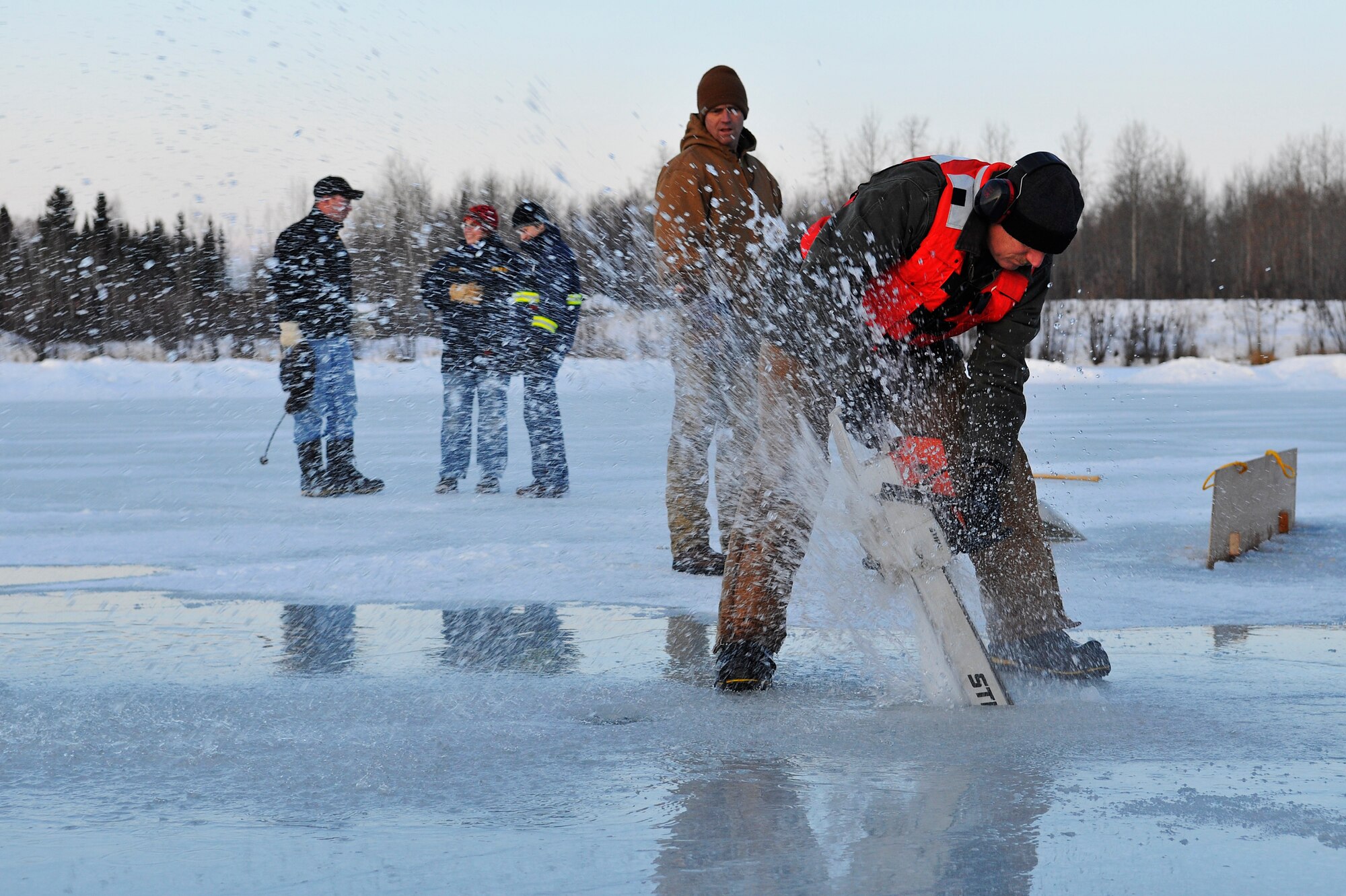 Randall Smith uses a chainsaw to cut through ice during a training scenario that focused on oil spills Dec. 1, 2009, Eielson Air Force Base, Alaska. The chainsaw was used to help construct underwater dams that help divert oil to specific locations based on underwater current. Mr. Smith is the Hazard Waste Disposer Supervisor assigned to the 354th Civil Engineering Squadron. The training was hosted by the U.S. Navy Supervisor of Salvage and Diving team. (U.S. Air Force photo/Staff Sgt. Christopher Boitz)