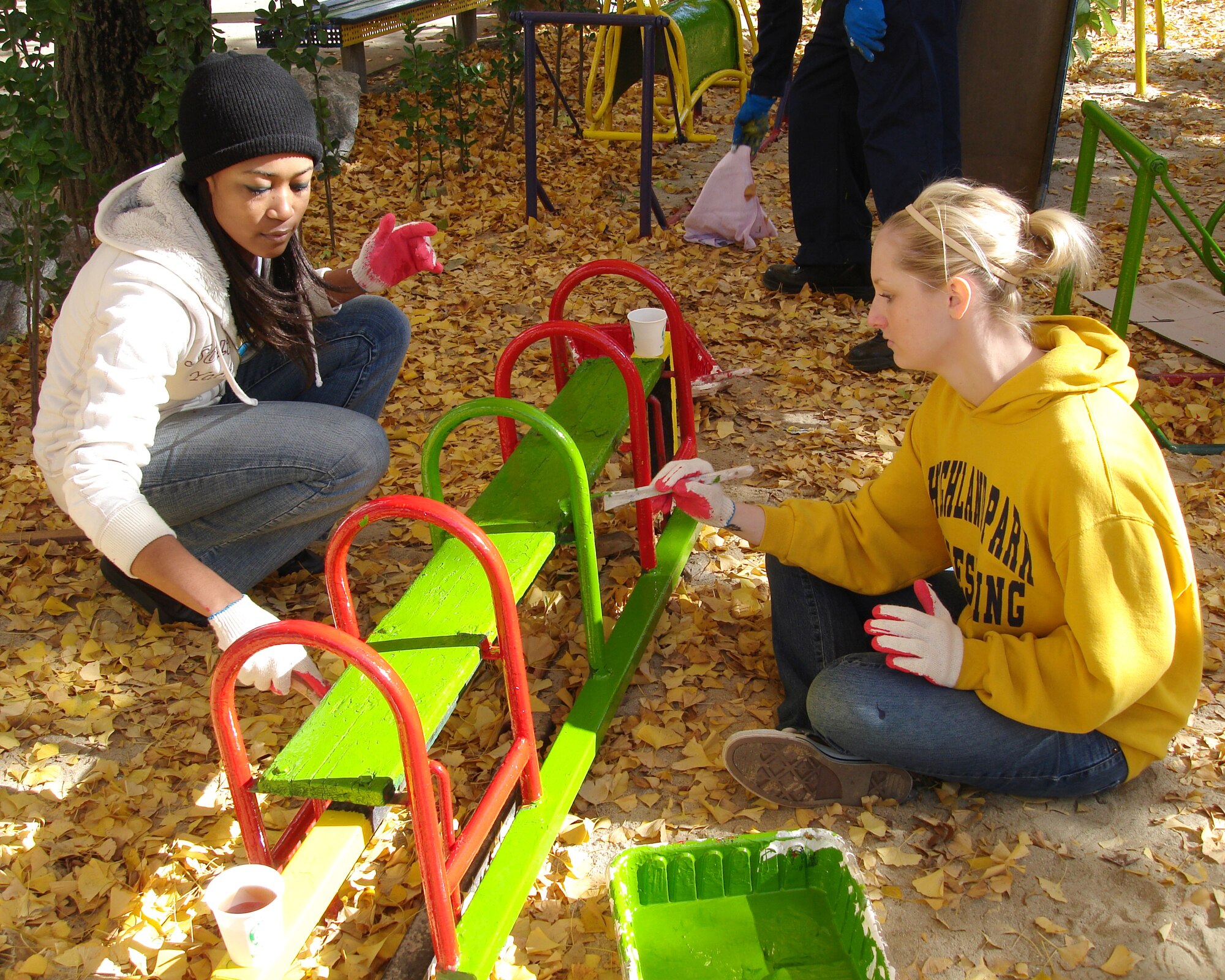 KUNSAN AIR BASE, Republic of Korea -- Senior Airmen Ktreese Rodriquez and Keri Ecker, 8th Medical Operation Squadron, paint playground equipment at the Ilmagwon Orphanage Nov. 21. Sixteen Airmen made a difference by donating their time to paint the Ilmagwon Orphanage and playground equipment, to maintain friendly relations with South Korean Civilization. (U.S. Air Force photo/Chaplain (Maj) Hector Colon)                               
