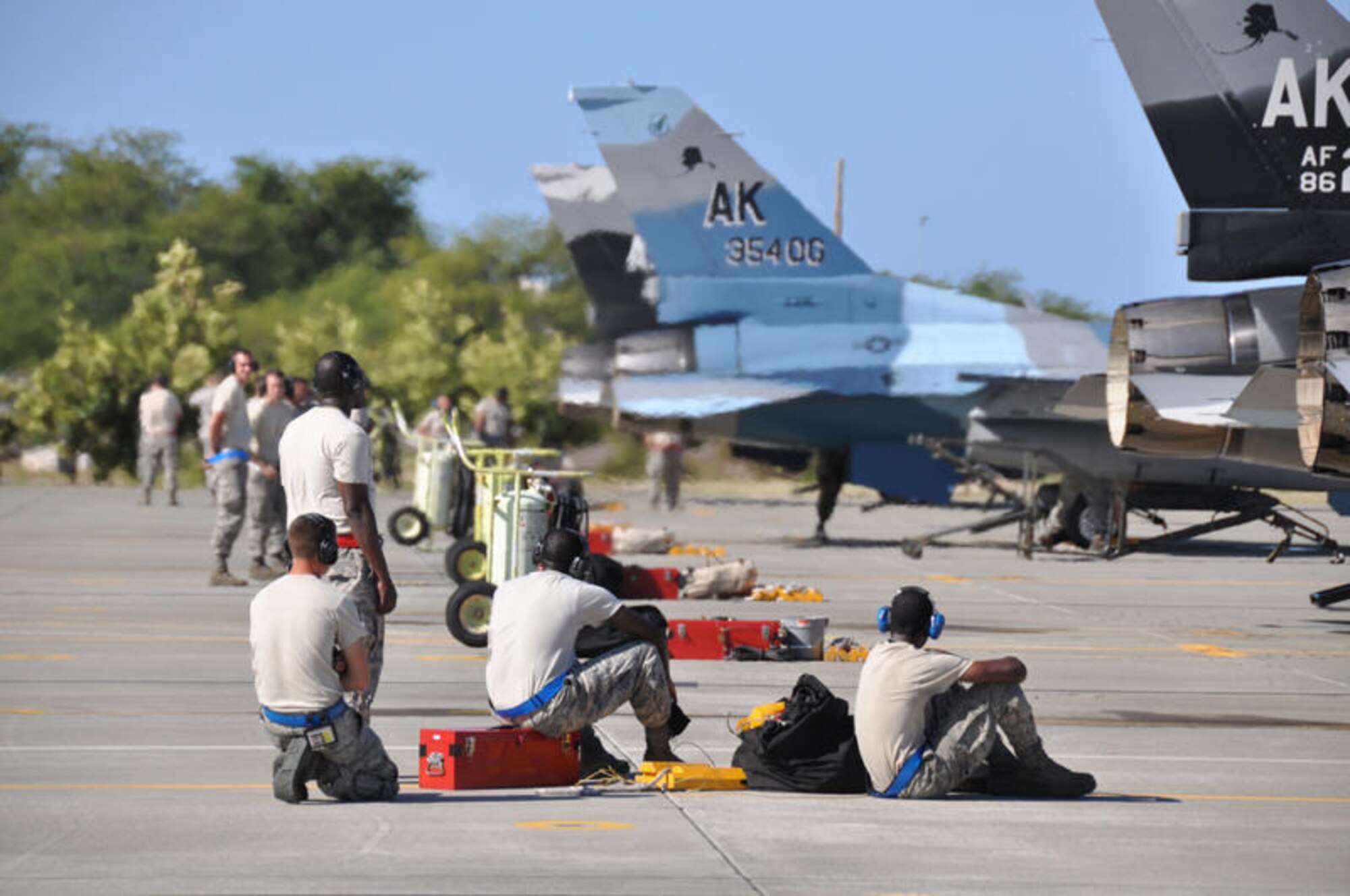 18th Aircraft Mainenance Squadron maintainers work around F-16 Fighting Falcon Agressor aircraft from the 18th Agressor Squadron at Hickam Air Force Base, Hawaii. The squadron, from Eielson Air Force Base, Alaska, functions to train aircrews through realistic threat replication in a simulated combat environment. It deploys mobile training teams throughout PACAF from April through October each year to conduct unit-level training. (Department of Defense photo/Cohen A. Young)