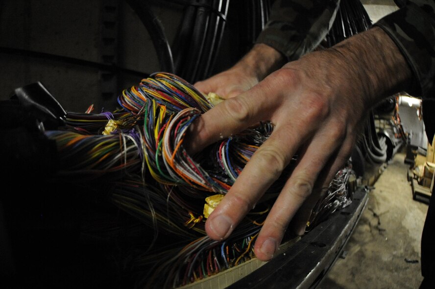WHITEMAN AIR FORCE BASE, Mo., - Staff Sgt. Carl Smith, 509th Communication Squadron, pushes wires back into one of the main network lines that branches out to connect the base, Dec. 1. The communication focal point provides customers on base a one-stop shop, servicing phone and network servers, base-wide.  (U.S. Air Force Photo/Airman 1st Class Carlin Leslie)(released)