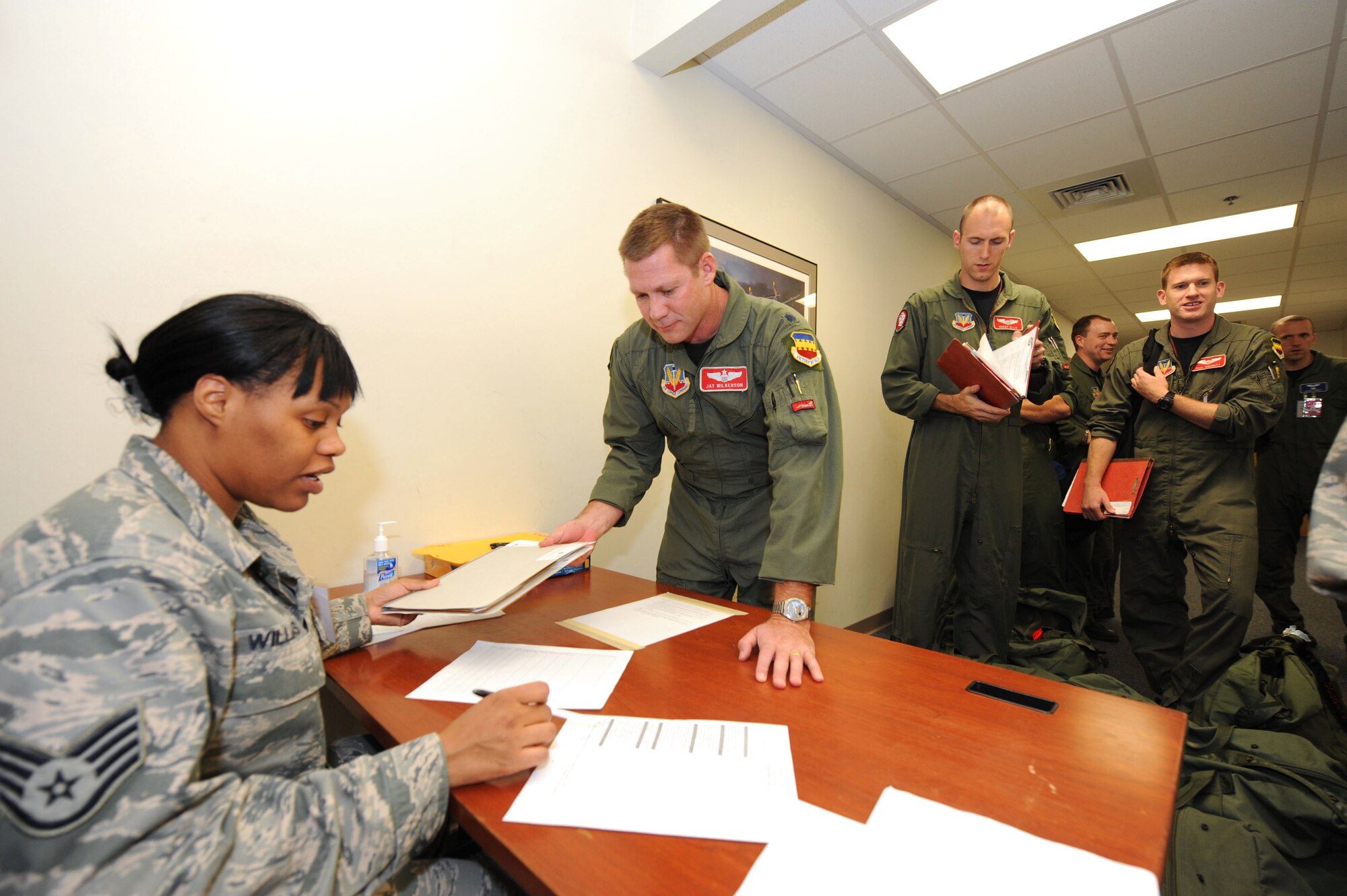 SHAW AIR FORCE BASE, S.C. -- Staff Sgt. Shavonne Williams, 20th Force Support Squadron, inspects a mobility folder for Lt. Col. James Wilkerson, 77th Fighter Squadron, at the Chandler Deployment Processing Center during Shaw's operational readiness exercise Dec. 1. (U.S. Air Force photo/Tech. Sgt. Louis Rivers)