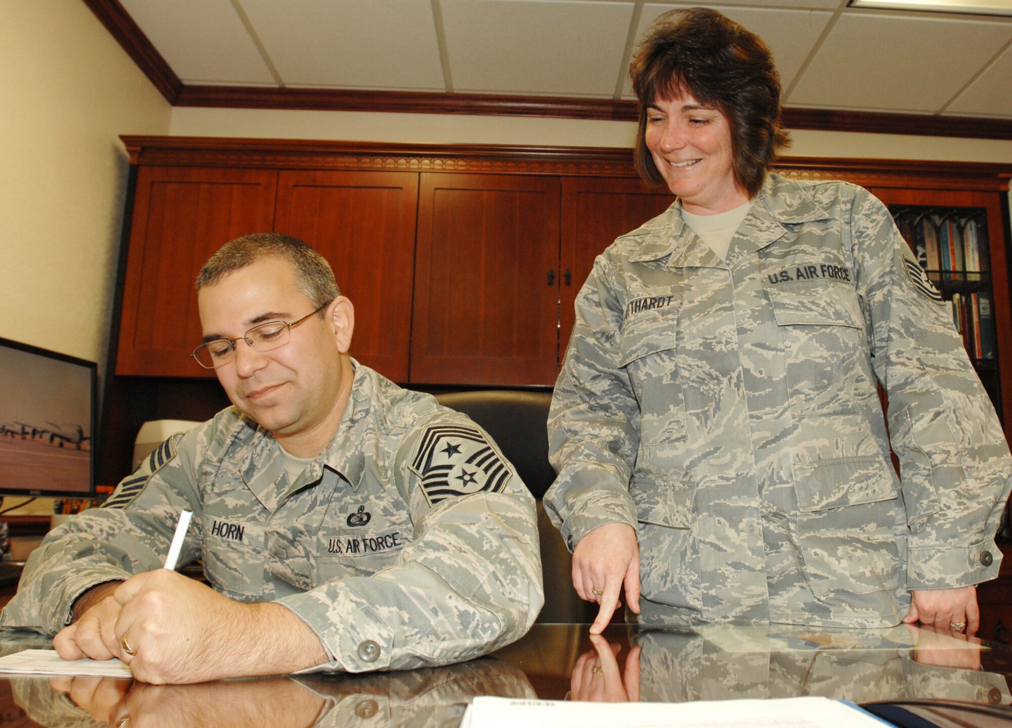 Tech. Sgt. Crystal Gotthardt, 22nd Air Refueling Wing combined federal campaign representative, watches Chief Master Sgt. Timothy Horn, 22 Air Refueling Wing command chief, sign a 2009 Combined Federal Campaign pledge form Dec. 1, 2009, at McConnell Air Force Base, Kan. The CFC is the world’s largest annual workplace charity campaign. McConnell members have until Dec. 15 to make donations to their group-level representatives.  (U.S. Air Force photo/Staff Sgt. Jamie Train)