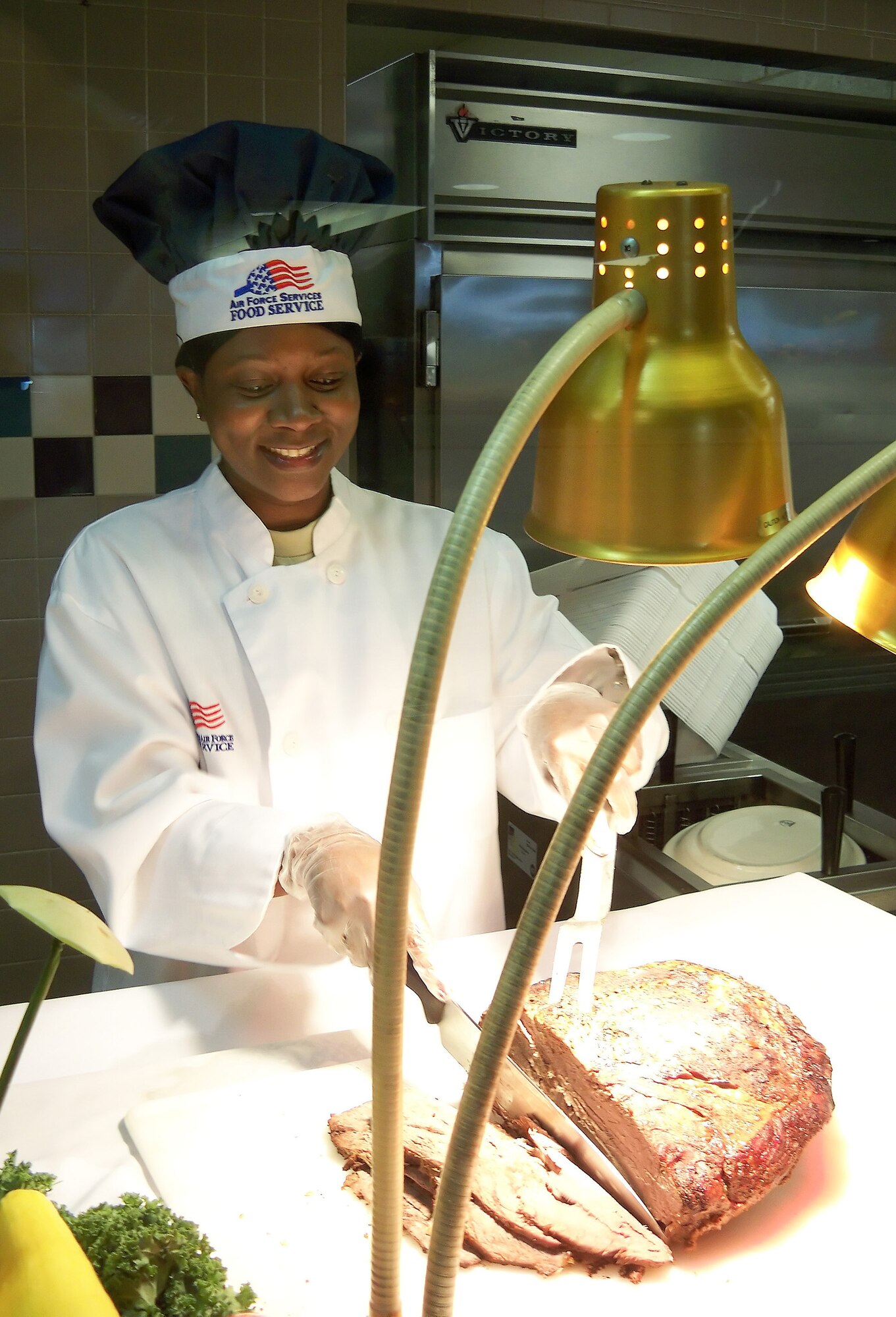 Chief Master Sgt. Cassandra Crawford-Bice, 436th Mission Support Group superintendent, carves roast beef at the Patterson Dining Facility Nov. 26. Wing leadership served Thanksgiving meals to Dover Airmen and retirees for the holiday. (U.S. Air Force photo/ Airman 1st Class Shen-Chia Chu) 