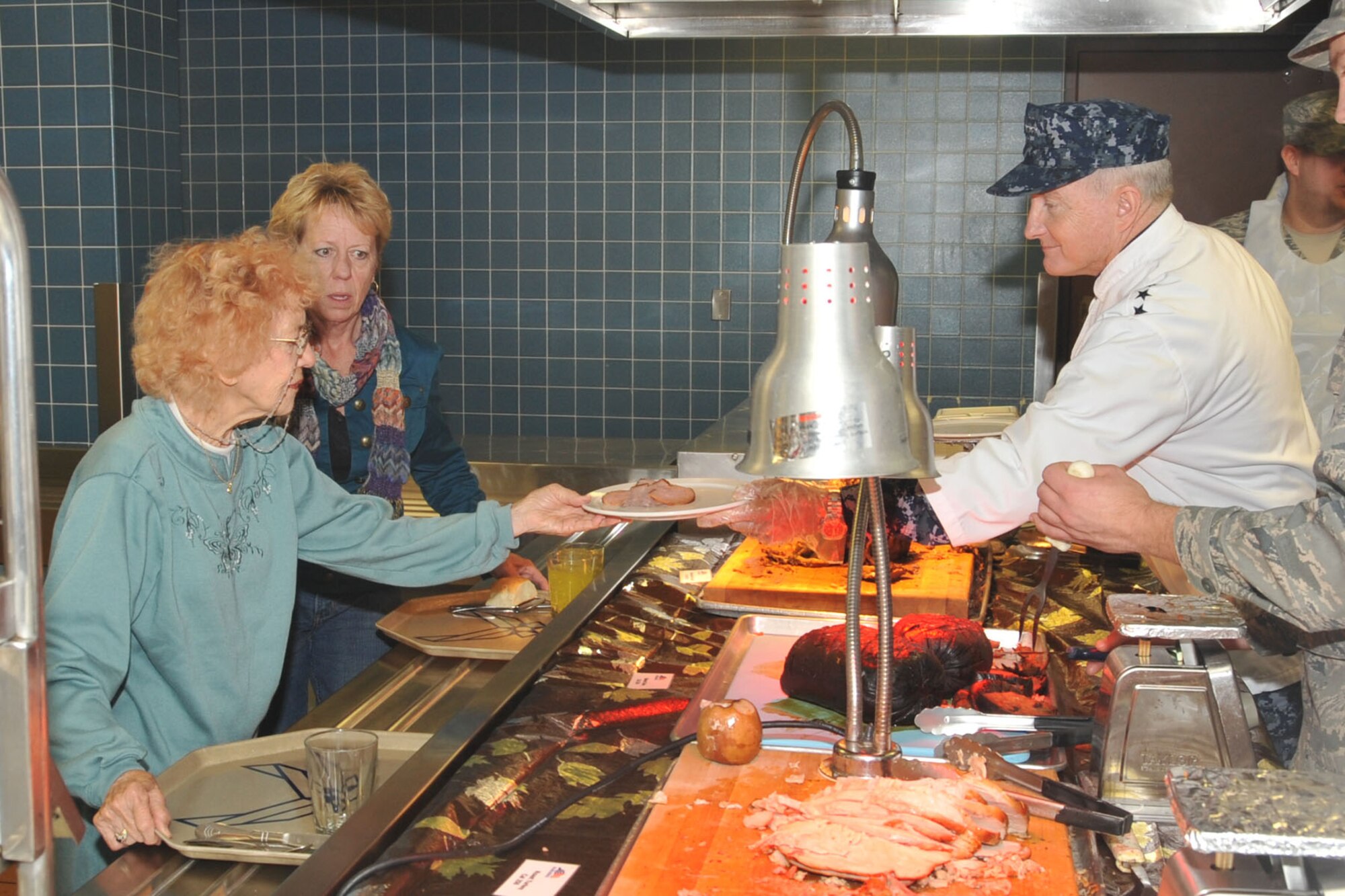 OFFUTT AIR FORCE BASE, Neb. - Vice Adm. Carl V. Mauney, U.S. Strategic Command vice commander, hands a plate of food to Mary Iverson, retired Chief Master Sgt. Jerry Wendling's mother-in-law from St. George, Utah, Nov. 26 at the King Dining Facility here, during Thanksgiving dinner. Ms. Iverson visited Chief Wendling for the Thanksgiving holiday. Admiral Mauney along with 55th Wing senior leaders volunteered to serve Thanksgiving meals to members of Team Offutt and their families to thank them for their service and sacrafice. U.S. Air Force Photo by Stephen Cunningham