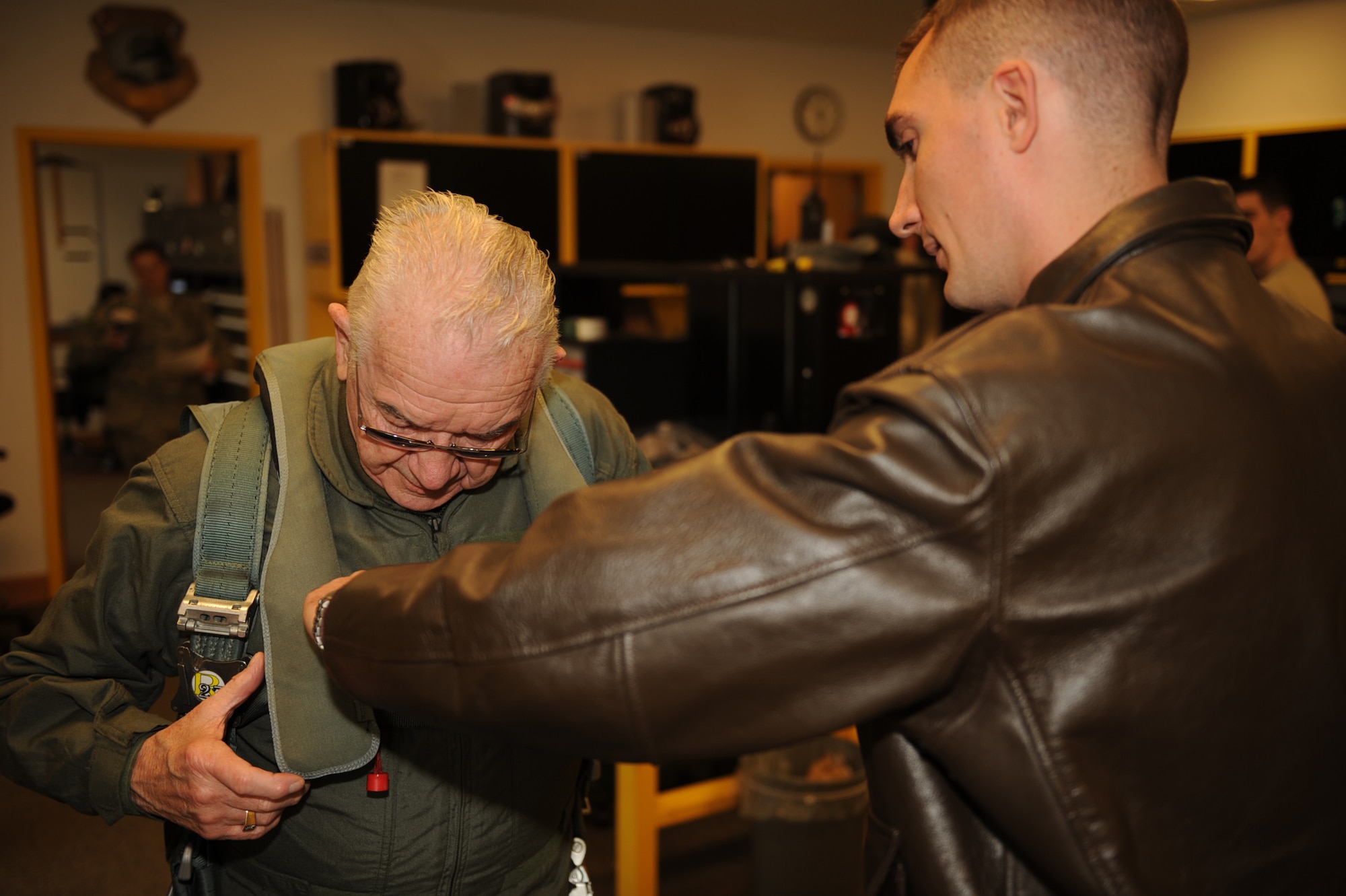 Capt. David Kopp, a 336th Fighter Squadron weapons system officer, assists Elmer Bryans, Retiree Activities Office director, in correctly putting on his flight suit before a taxi ride in an F-15E Strike Eagle on Seymour Johnson Air Force Base, N.C., Nov. 30, 2009. Mr. Bryans received the taxi ride from Col. Mark Kelly, 4th Fighter Wing commander. (U.S. Air Force photo/Senior Airman Ciara Wymbs) 