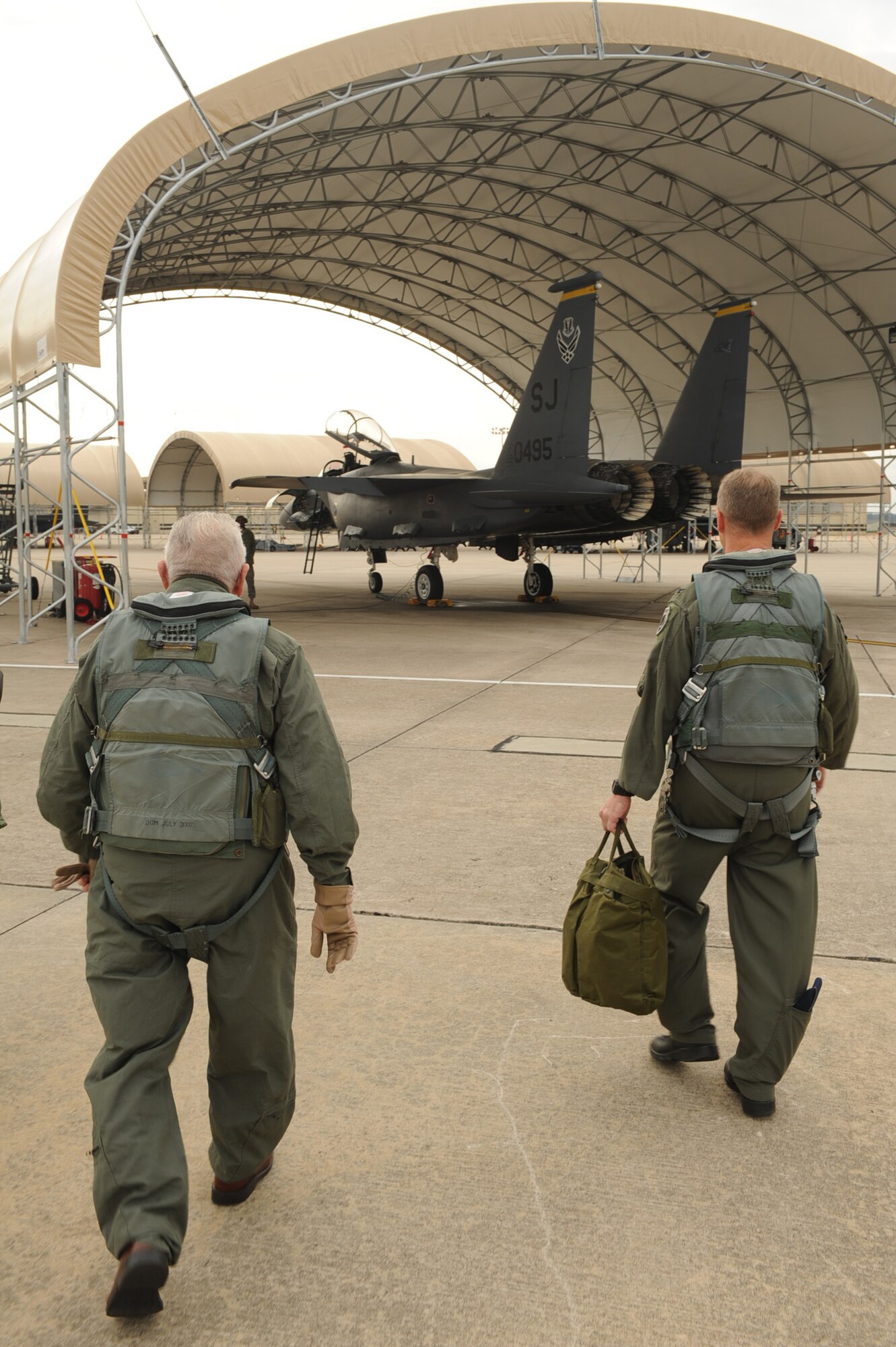 Col. Mark Kelly, 4th Fighter Wing commander, and Elmer Bryans, Retiree Activities Office director, step to an F-15E Strike Eagle for a taxi ride on Seymour Johnson Air Force Base, N.C., Nov. 30, 2009. Mr. Bryans, a retired senior master sergeant, received a taxi ride because of the volunteer service he has done on base during the last three years. (U.S. Air Force photo/Senior Airman Ciara Wymbs) 