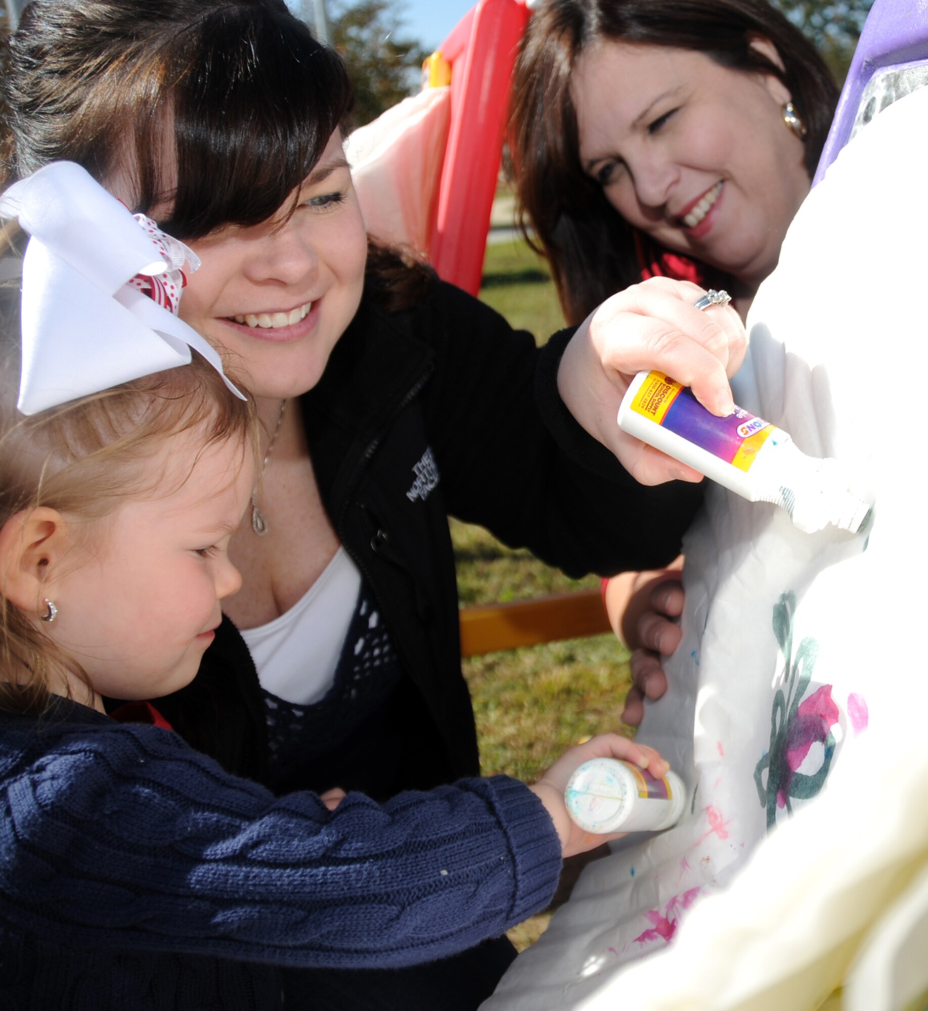 Mackenzie Townsend, 2, does dot art with her mom, Devann Townsend, and grandmother, Sharon Warning, at  family fun day.  Mackenzie’s dad is Airman 1st Class Austin Townsend, Barksdale Air Force Base, La.  (U.S. Air Force photo by Kemberly Groue)