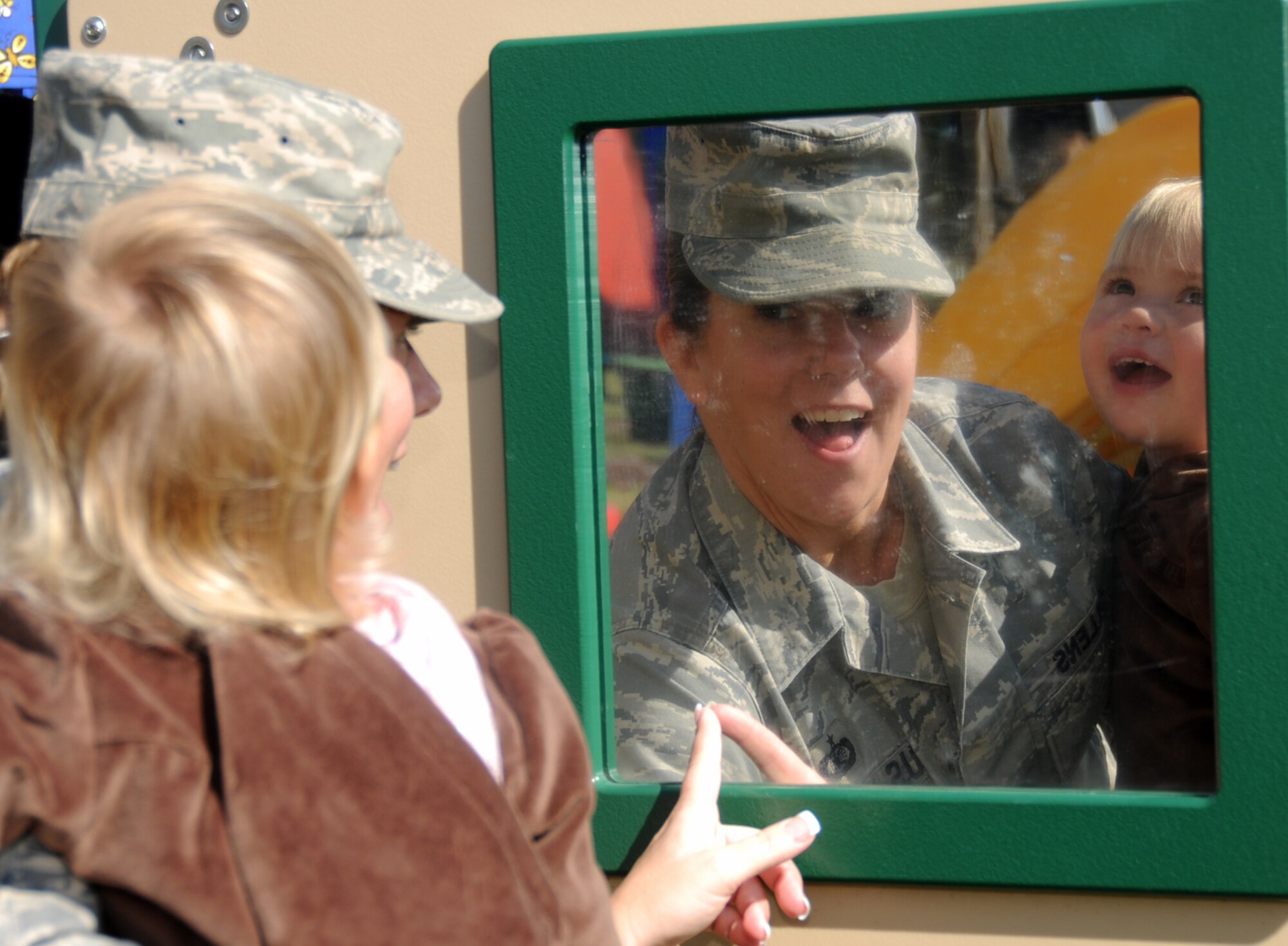 Tech. Sgt. Valerie Mullins, president of the child development center’s parent advisory board, and her 1-year-old daughter, Katie, laugh at their mirror images at the child development center’s family fun day Nov. 19.  Katie’s mom is assigned to the 81st Communications Squadron and her dad, Master Sgt. Steven Mullens, is from the 85th Engineering Installation Squadron. (U.S. Air Force photo by Kemberly Groue)