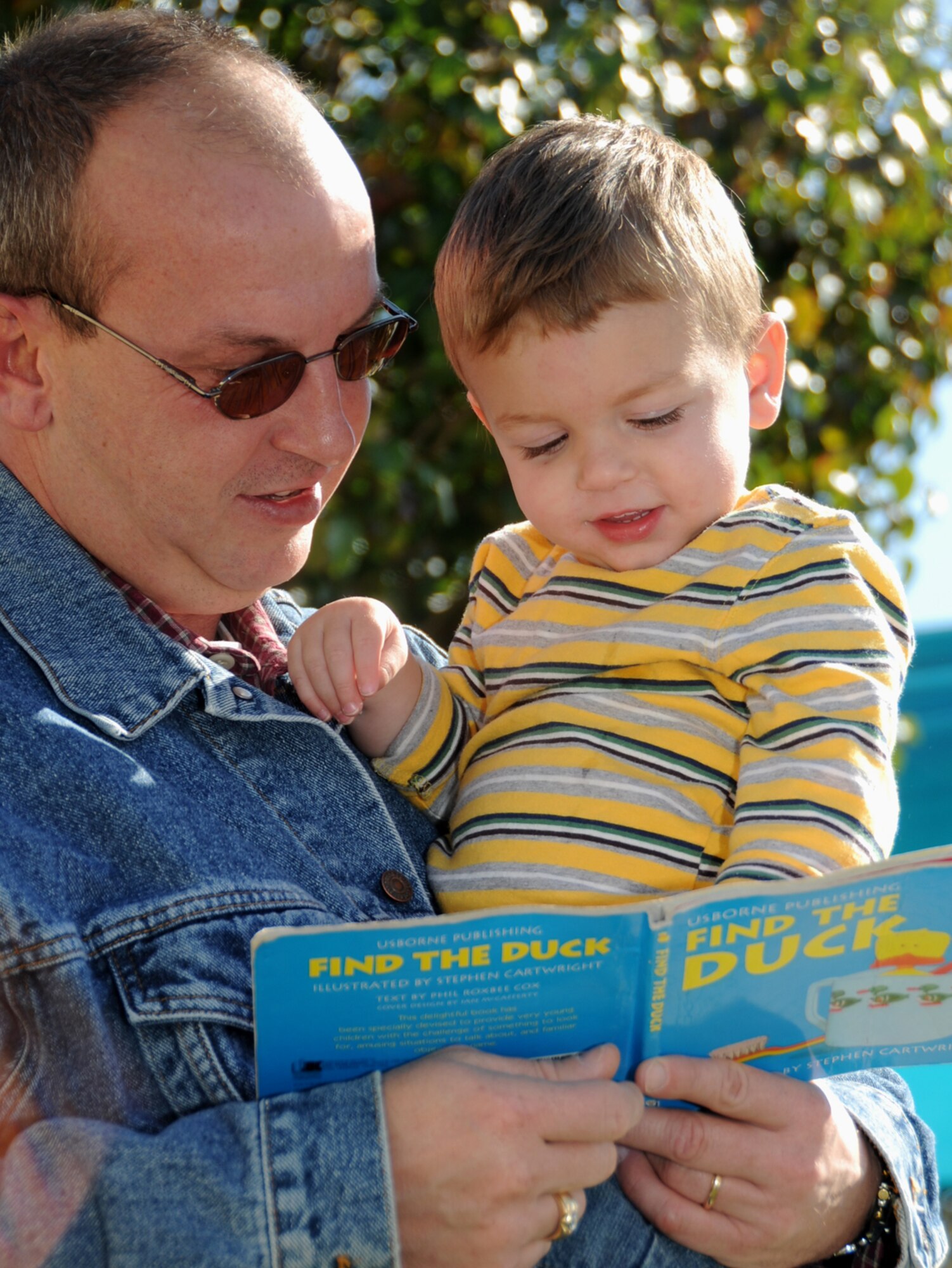 Randy Sherer, husband of Senior Airman Tammy Sherer, 81st Medical Support Squadron, reads to their 1-year-old son, Will, at family fun day Nov. 19. (U.S. Air Force photo by Kemberly Groue)