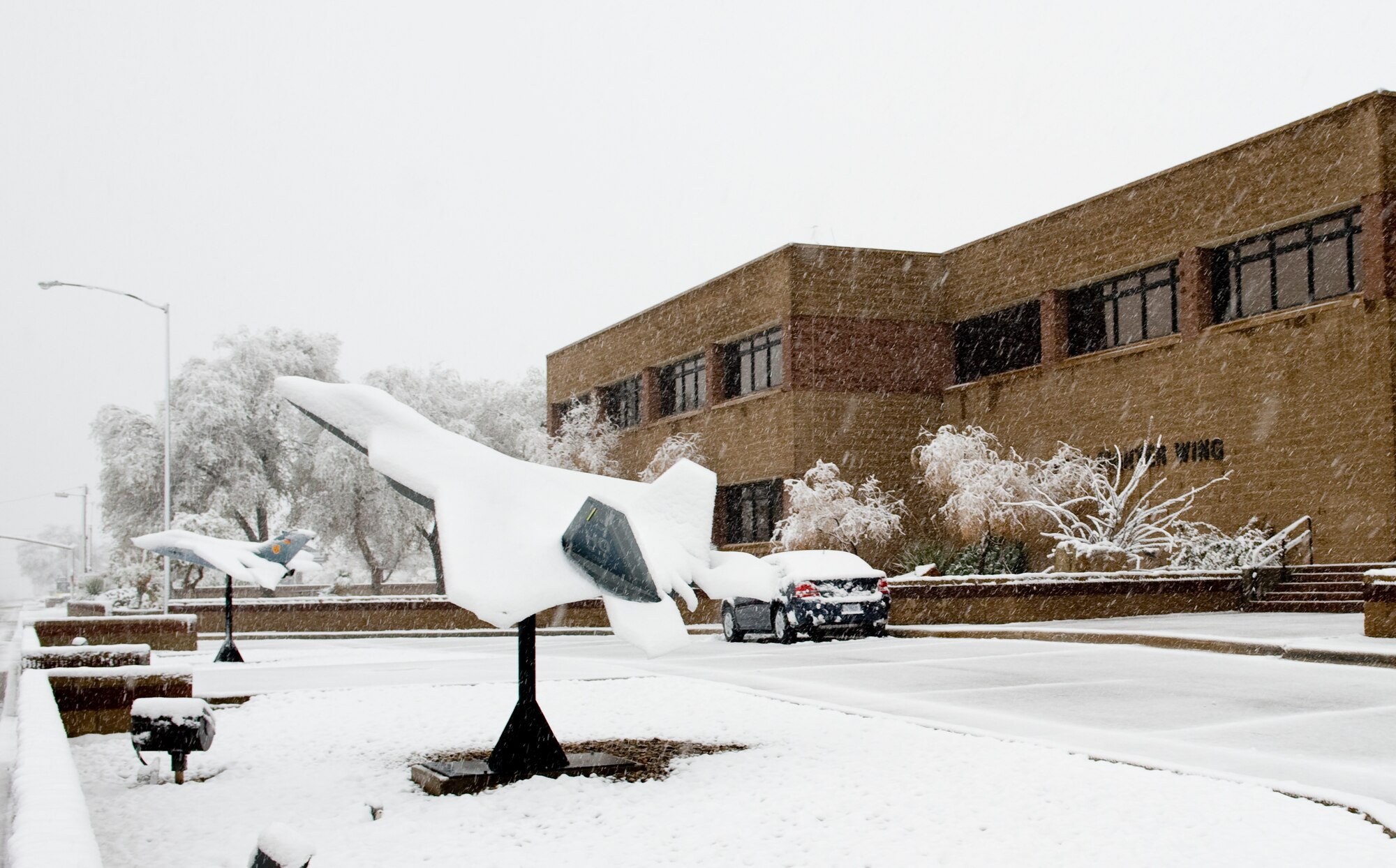HOLLOMAN AIR FORCE BASE, N.M. -- Snow falls in front of the 49th Fighter Wing Headquarters Building Dec. 1. The National Weather Service in El Paso, Texas, issued a winter storm warning from noon Nov. 30 to 5 a.m. Dec. 1. Between three and eight inches of snow was expected, according to NWS.(U.S. Air Force photo by Tech. Sgt. Alan Port)