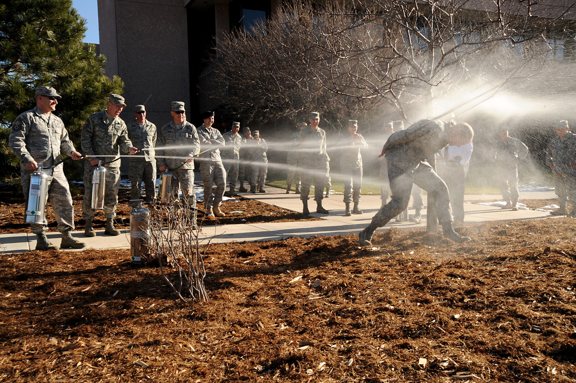 Chief Master Sgt. Tim Omdal, who served as the 21st Space Wing command chief from Sept. 12, 2006 until Nov. 30, 2009, is hosed down in front of the 21st SW headquarters building by (left to right) Chief Master Sgt. Thomas Trottier, 21st Medical Group superintendent, Chief Master Sgt. Robert Nussbaum, 21st Civil Engineer Squadron superintendent, and Chief Master Sgt. Randy Lacombe, 50th Space Wing command chief. Chief Omdal was ‘detained’ by members of the 21st Security Forces Squadron Nov. 24 before being farewelled by the group of chiefs. After nearly 30 years of service, Chief Omdal will officially retire from active duty Dec. 11 in a 10 a.m. ceremony at The Club. (Air Force photo by Roberta McDonald)