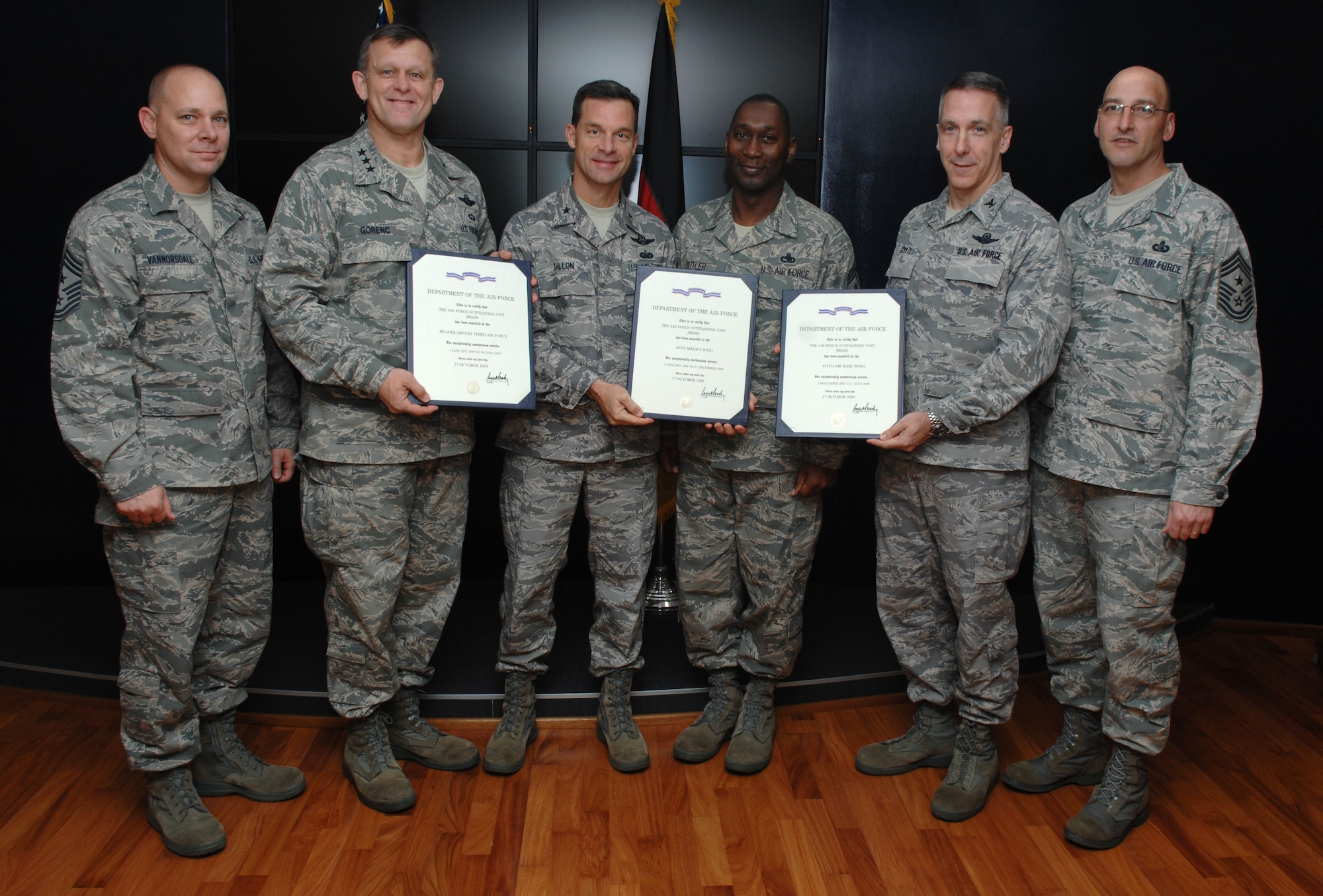 (Left to right) U.S. Air Force Chief Master Sgt. Dennis Vannorsdall, 3rd Air Force command chief; Lt. Gen. Frank Gorenc, 3rd AF commander; Brig. Gen. Mark Dillon, 86th Airlift Wing commander; Chief Master Sgt. Vernon Butler, 86th AW command chief; Col. Thomas Gould, 435th Air Ground Operations Wing commander; and Chief Master Sgt. Stippel, 435th AGOW command chief, stand with the Air Force Outstanding Unit Award certificates for their units. Each unit won the award for their exceptional service, and Ramstein Airmen assigned to one of the three units during the timeframe of their awards are authorized to wear the AFOUA ribbon. (U.S. Air Force photo by Airman 1st Class Brittany Perry) 