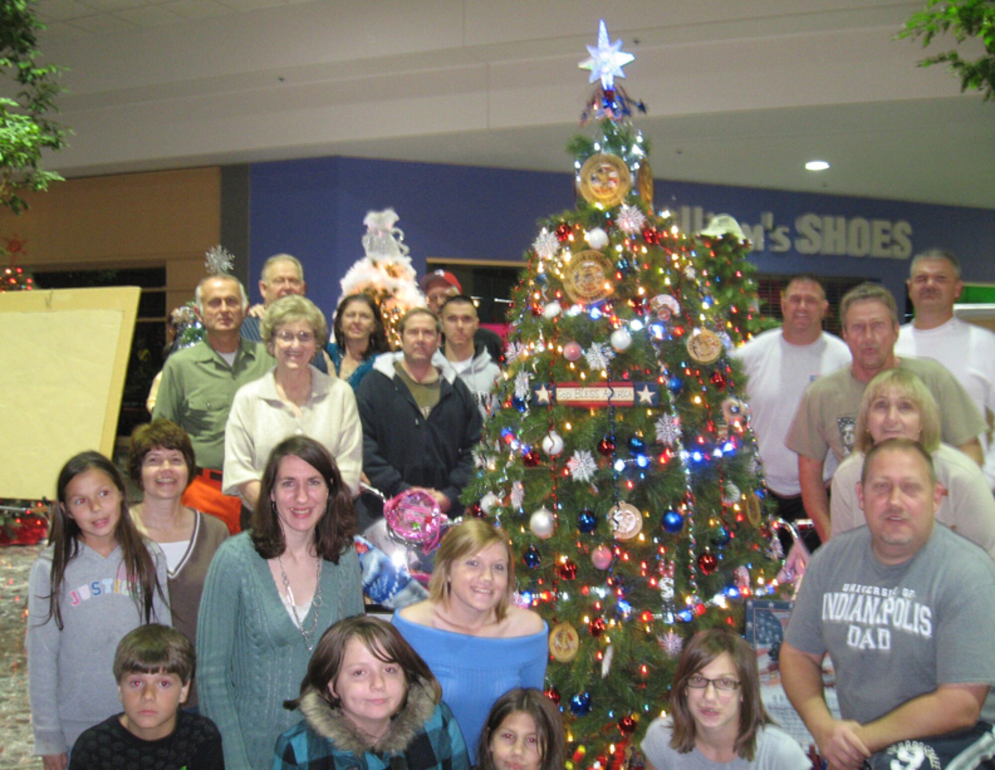 KOKOMO, Ind., -- Volunteers from the 434th Maintenance Group, family and friends gather round a Christmas tree they had decorated during their off-duty time. The tree was auctioned off during the "We Care Trim-A-Tree Festival" to help raise money for a local charity that assists needy families during the holiday season. The volunteers from Grissom won the People's Choice Award for its "A Red, White and Blue Christmas Tree." The volunteer Christmas tree project was another in a long line of community outreach events involving Grissom personnel.  (Photo courtesy Keith McAndrews and Ashley Miller)