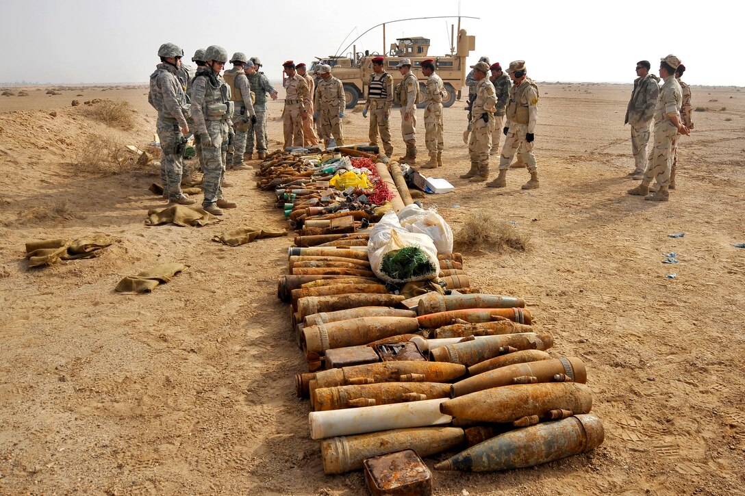 U.S. Air Force explosive ordnance technicians and Iraqi soldiers prepare to destroy captured enemy ordnance with a controlled detonation on Forward Operating Base Mahmudiyah, Iraq, Nov. 23, 2009.