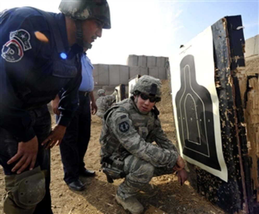 U.S. Air Force Staff Sgt. Michael Gomez, with Detachment 2, 732nd Expeditionary Security Forces Squadron, assesses an Iraqi police officer’s target on a firing range in Baghdad, Iraq, on Nov. 21, 2009.  