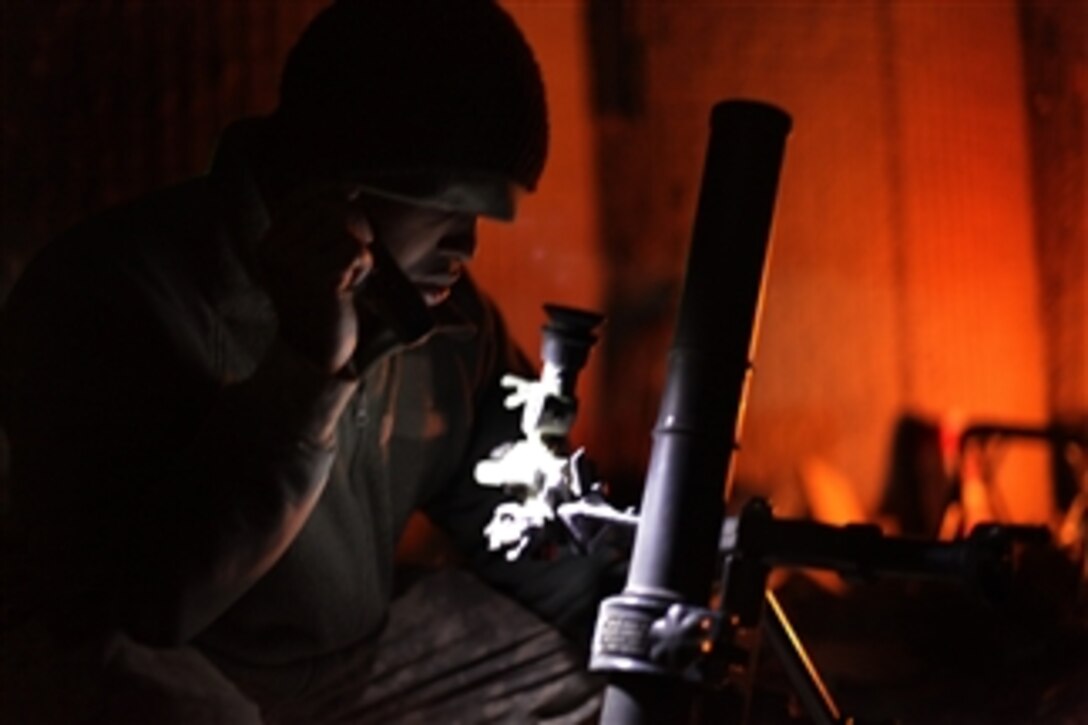 A U.S. Army soldier inspects his 60mm mortar system in preparation for a fire mission at Combat Outpost Cherkatah, in Khowst province, Afghanistan, on Nov. 26, 2009.  