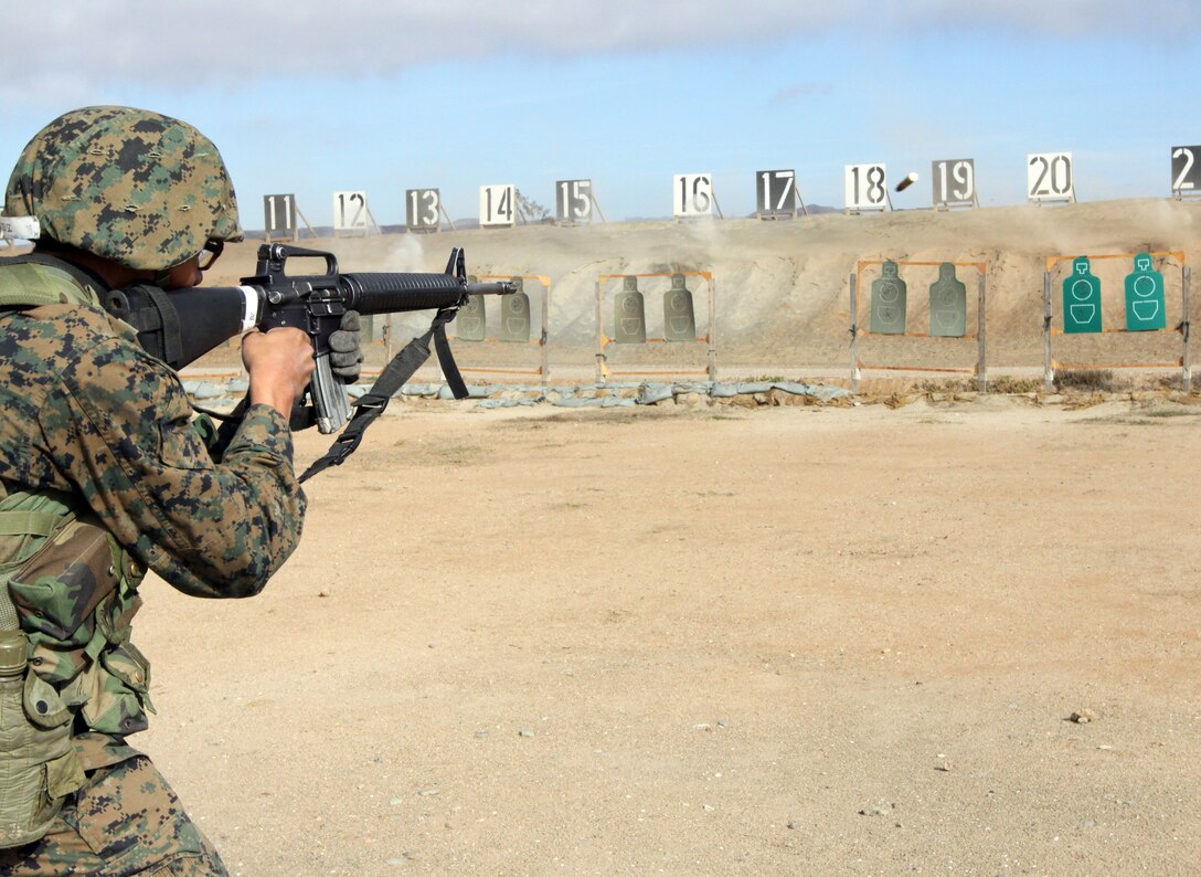 A Company F recruit aims in at a close-range target at 25 yards away during Table 2 Basic Marksmanship Course Dec. 1 on Edson Range, Marine Corps Base Camp Pendleton, Calif. The recruit wears a full combat load including a Kevlar helmet and flak jacket.  At the 25 yard line, recruits earn two points for each shot in the designated areas on the targets and one point outside the selected area.