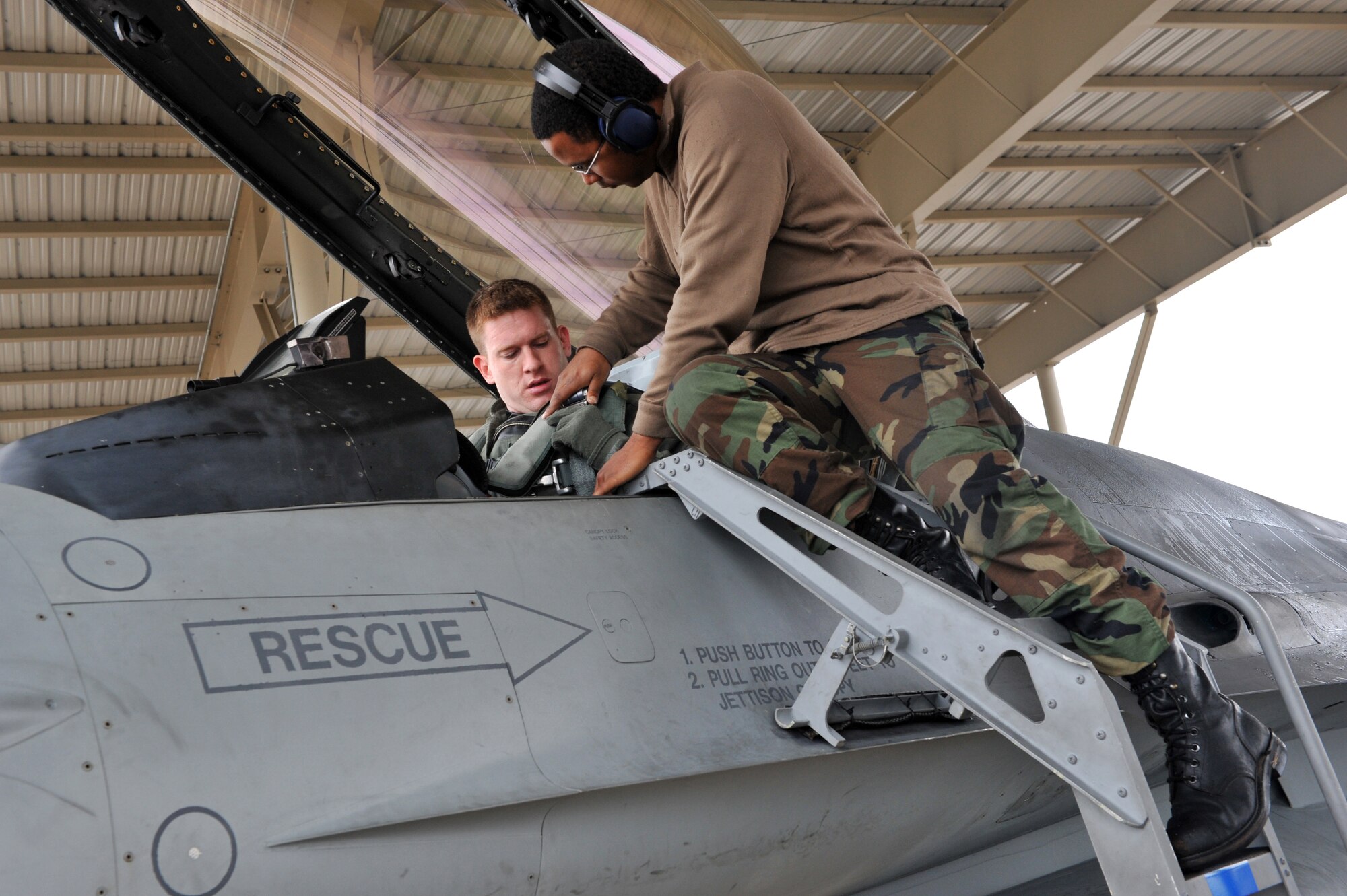 SHAW AIR FORCE BASE, S.C. -- Captain Paul Doughty of the 77th Fighter Squadron receives help connecting his harness to the ejection seat in his F-16 prior to takeoff during an operational readiness exercise. The 20th Fighter Wing conducts Phase I OREs to practice deploying. (U.S. Air Force photo/Tech. Sgt. Josef Cole)
