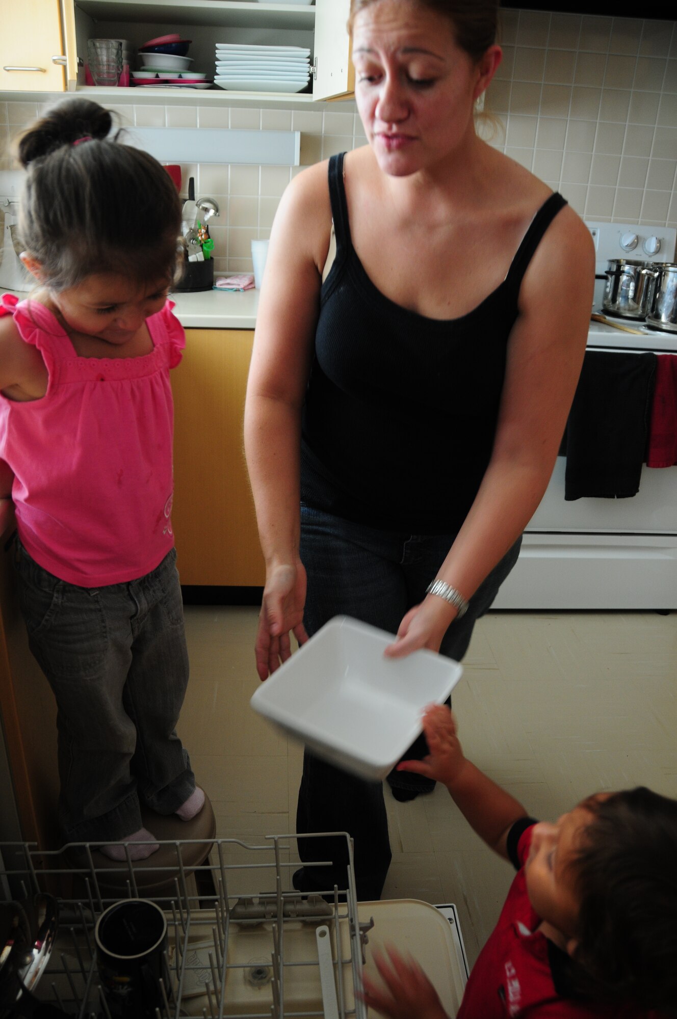 Staff Sgt. Christina Martinez (C), a single mother and operations management contingency instructor with Detachment 1, 554th Red Horse Civil Engineering Squadron, makes doing the dishes an exercise in teamwork for her two children Lilianna (L) and Mateo (R) at Kadena Air Base, Japan. (U.S. Air Force photo/Staff Sgt. Lakisha A. Croley)