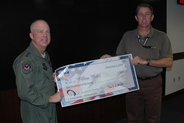 Lt. Gen. Donald Wurster, Air Force Special Operations commander, presents a $10 thousand check to William Walter, an analyst at AFSOC, at AFSOC Headquarters at Hurlburt Field, Dec. 2. Mr. Walter won the check after submitting a cost-saving proposal to the Innovative Development through Employee Awareness Program.  (Air Force photo by Airman 1st Class Joe McFadden)