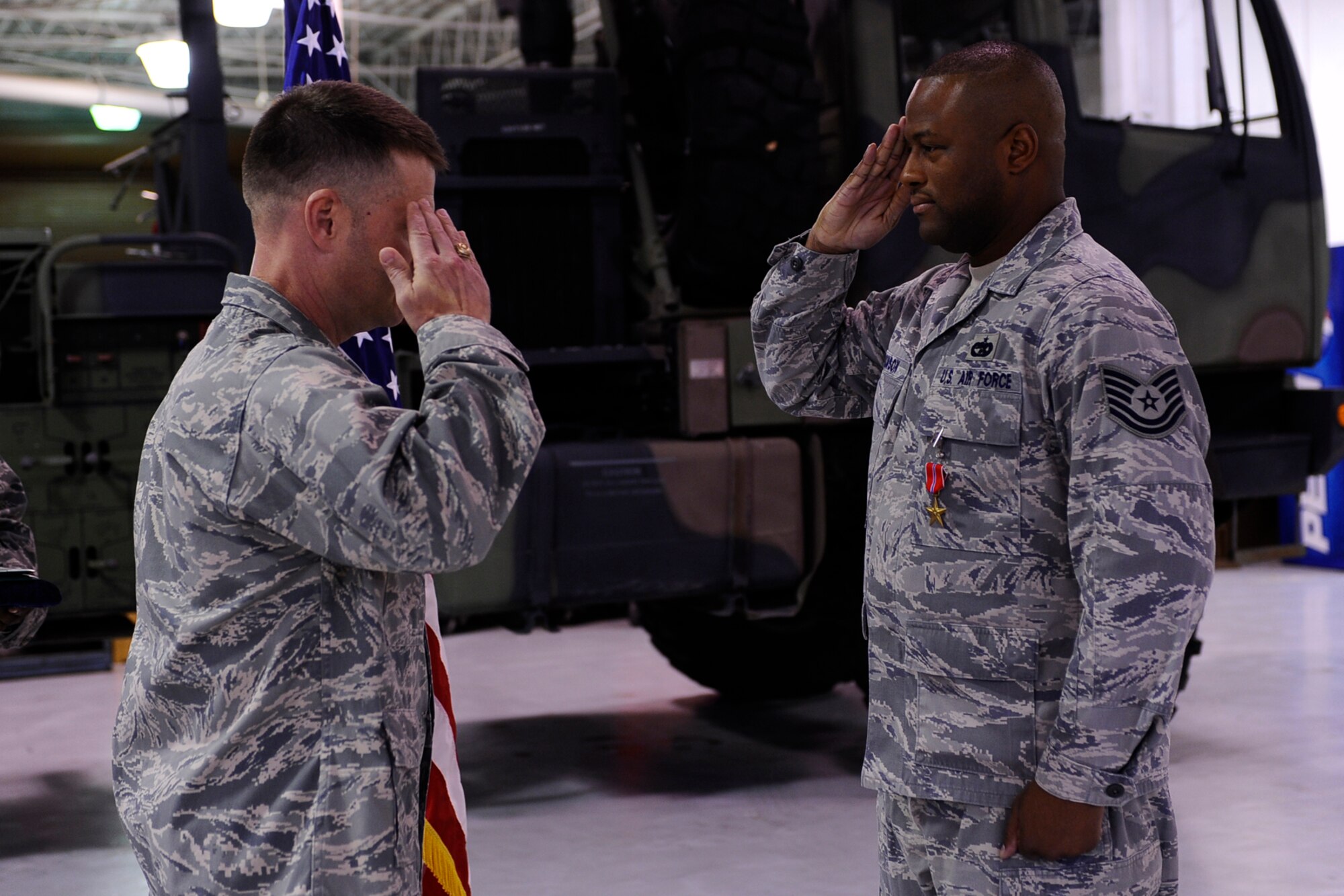 Col. Greg Lengyel, 1st Special Operations Wing commander, salutes Tech. Sgt. Dameon Jackson, 1st Special Operations Logistics Readiness Squadron, after presenting him with the Bronze Star at the vehicle maintenance compound at Hurlburt Field Dec. 1. Sergeant Jackson received the medal after serving as convoy commander of the U.S. Army’s 70th Medium Truck Detachment in support of Operation Iraqi Freedom. (Air Force photo by Senior Airman Julianne Showalter)