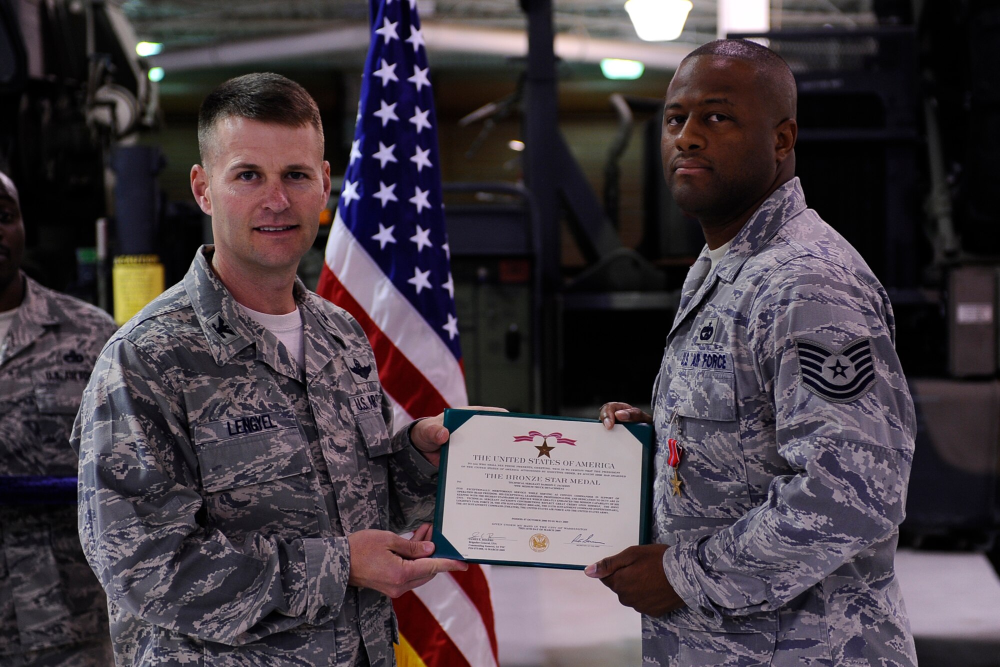 Col. Greg Lengyel, 1st Special Operations Wing commander, presents the citation accompanying the Bronze Star to Tech. Sgt. Dameon Jackson, 1st Special Operations Logistics Readiness Squadron, at the vehicle maintenance compound at Hurlburt Field Dec. 1. Sergeant Jackson received the medal after serving as convoy commander of the U.S. Army’s 70th Medium Truck Detachment in support of Operation Iraqi Freedom. (Air Force photo by Senior Airman Julianne Showalter)
