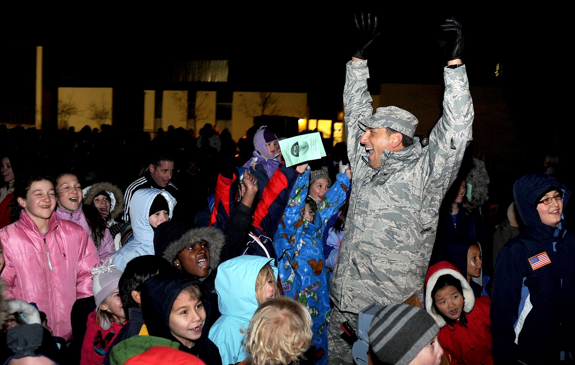 Col. Rick LoCastro and children cheer as Santa Claus arrives at the Community Center Chapel during a Christmas tree lighting ceremony Dec. 1, 2009. More than 200 people attended the event. Colonel LoCastro is the 10th Air Base Wing commander. (U.S. Air Force photo/Johnny Wilson)