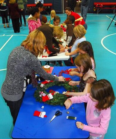 Children, workers and volunteers team up to decorate holiday wreaths at the Youth Programs Center here Dec. 1. The wreaths will be put on display during the Festival of Wreaths scheduled for Dec. 10 and later donated to the Medical University of South Carolina Children's Hospital. (U.S. Air Force photo/Staff Sgt. Daniel Bowles)