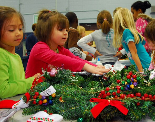 Ariana Ruiz, left, and Emily Coyt work together to decorate a holiday wreath at the Youth Programs Center here Dec. 1. Children, childcare workers and volunteers gathered together to decorate wreaths for donation to the Medical University of South Carolina Children's Hospital in support of the Festival of Wreaths scheduled to be held Dec. 10. Ariana is the daughter of Staff Sgt. Michael Ruiz who is with the 437th Aircraft Maintenance Squadron and Emily is the daughter of Staff Sgt. Virgil Smith who is with the 437th Operations Support Squadron. (U.S. Air Force photo/Staff Sgt. Daniel Bowles)
