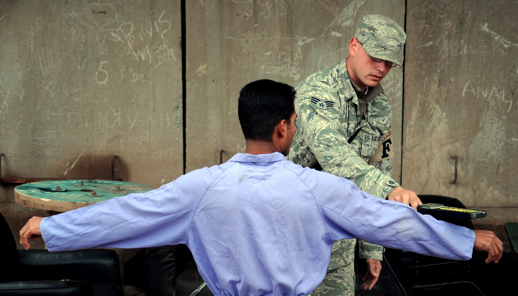 Senior Airman Ruben Lopez checks local nationals for weapons or prohibited items as they enter the gravel yard Nov. 19, 2009 at Joint Base Balad, Iraq. Airmen deployed as FP escorts protect resources while providing safety and security on Joint Base Balad. Airman Lopez is a 332nd Expeditionary Civil Engineer Squadron force protection escort. (U.S. Air Force photo/Senior Airman Christopher Hubenthal) 