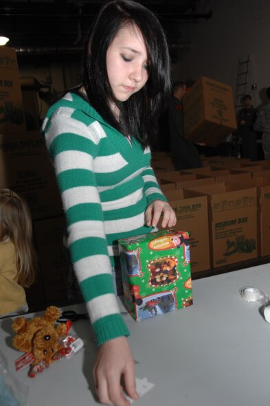 Kallan Randles, daughter of TSgt Daniel Randles wraps presents helping with the 116th Air Control Wing Family to Family program Tuesday Dec. 1 at Robins AFB, GA. The program gives unit members a chance to help the community and other military families by donating gifts and time to those needing some help during the holiday season. (GA ANG Photo by SMSgt Tom McKenzie)