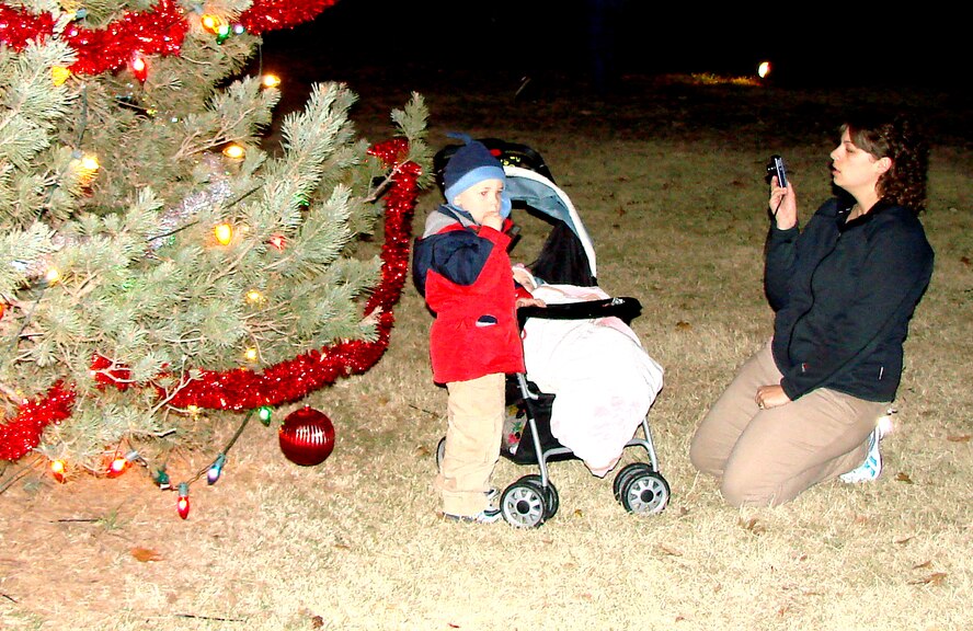Melissa Dwyer snaps a picture of her son, Dylan, by the Base Tree following the lighting ceremony held Dec. 1. The tree is decorated with 725 lights, large ornaments and garland that were hung by members of CSC Applied Technology's civil engineering grounds shop. Mrs. Dwyer’s husband, Capt. Rodney Dwyer, is assigned to the 3rd Fighter Training Squadron. (U.S. Air Force photo/ Joe B. Wiles)
