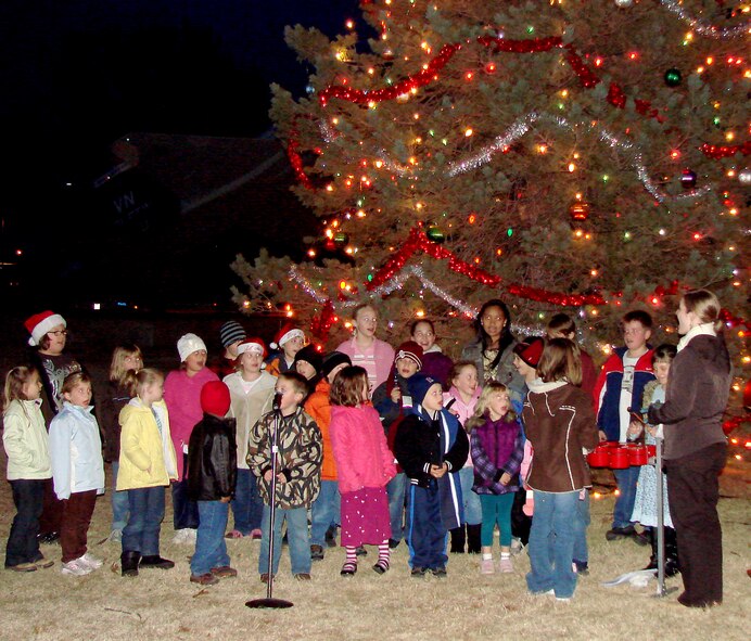 Children from Eisenhower Elementary School on base sing holiday songs lead by Melissa Amos, their music teacher, during the Vance Base Tree lighting ceremony Dec. 1. The tree, located near the T-38 static display across from the elementary school, has 725 lights, large ornaments and garland that were hung by members of CSC Applied Technology's civil engineering grounds shop. (U.S. Air Force photo/ Joe B. Wiles)