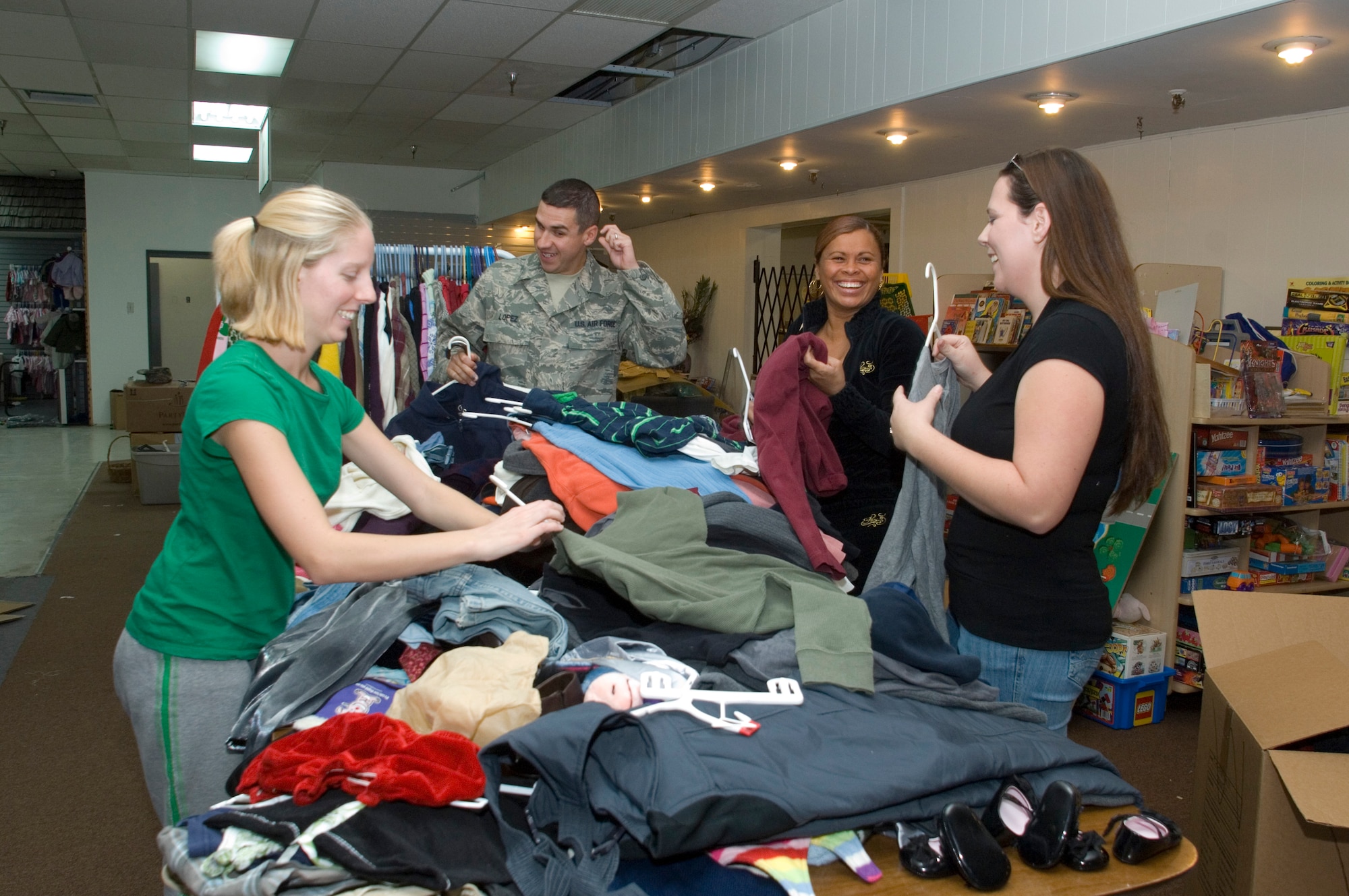 The Airman's Attic volunteers sort garments to be displayed in their proper section in time for the Attic's opening Jan. 5. From left: Ashley Perry, Airman 1st Class Lawrence Lopez, Anna Netoyer and Nicole Parker. (U.S. Air Force photo/Edward Cannon)
