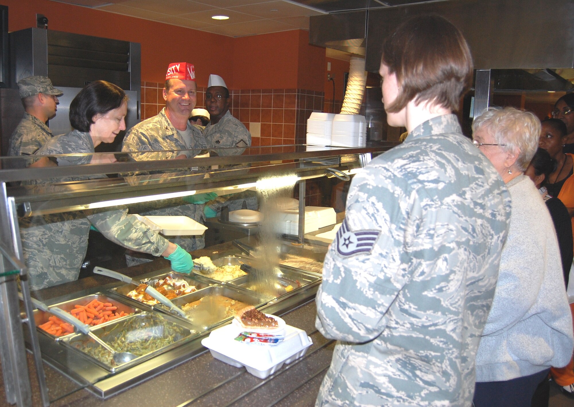 Cols. Stephanie McCann, 81st Diagnostics and Therapeutics Squadron commander, and David Garrison, 81st Medical Group deputy commander, serve Thanksgiving meals during lunch Nov. 19 in the Hungry Dragon cafeteria.  They joined other members of the senior leadership who volunteered to assist the nutritional medicine flight staff provide turkey, ham and trimmings to almost 650 diners.  This included 369 servings of roast turkey, 200 of holiday ham, plus sweet potatoes, cornbread stuffing, mashed potatoes, green bean casserole, baby carrots and  desserts.  On Thanksgiving Day, Keesler’s senior leaders served the holiday meal at Live Oak and Magnolia dining facilities.  (U.S. Air Force photo by Steve Pivnick)
