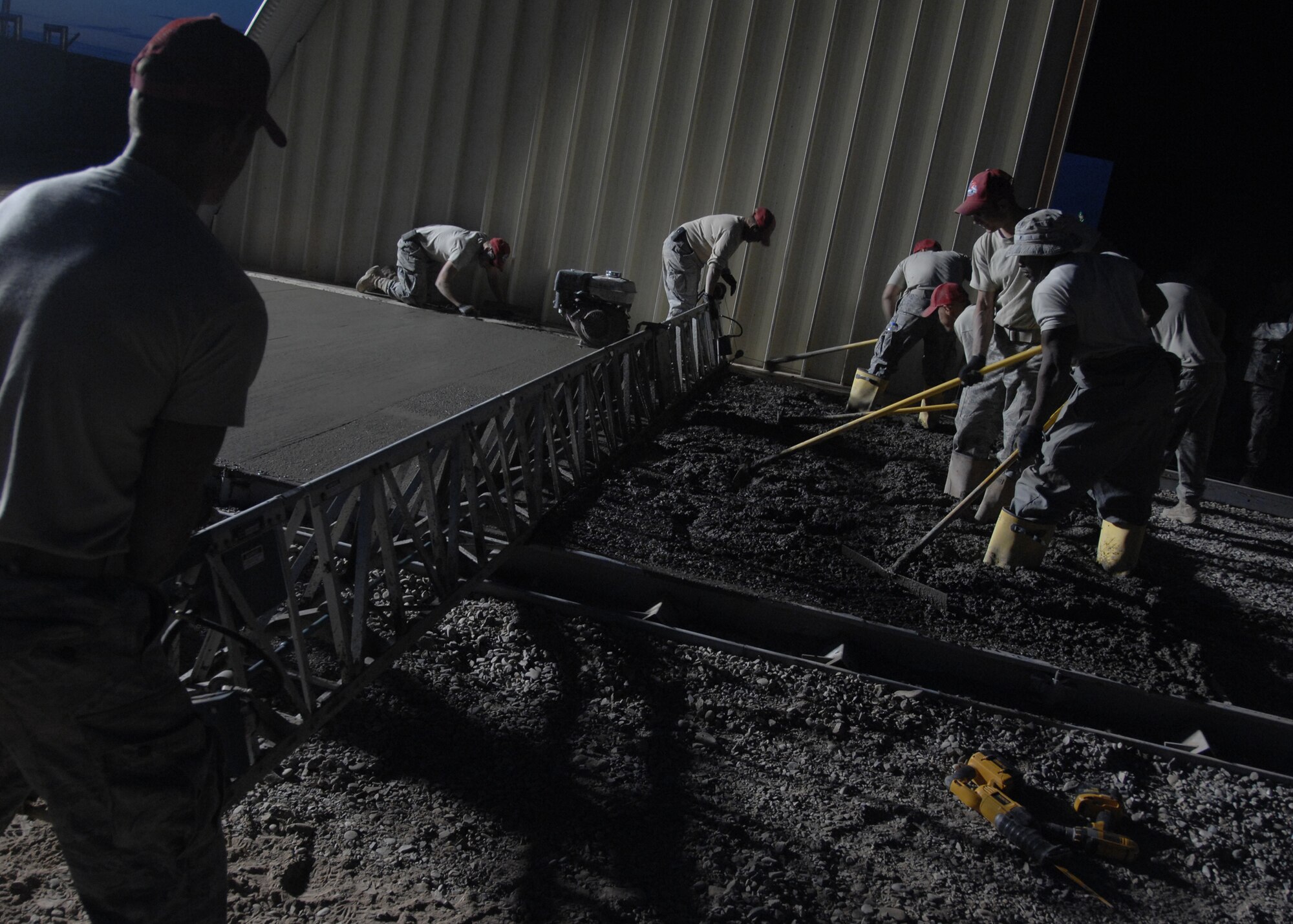 KANDAHAR AIRFIELD, Afghanistan - Members from the 823rd Rapid Engineer Deployable Heavy Operational Repair Squadron Engineers pour and flatten a cement slab during the construction of new structures here Nov. 28, 2009. (U.S. Air Force photo/Senior Airman Timothy Taylor) 
