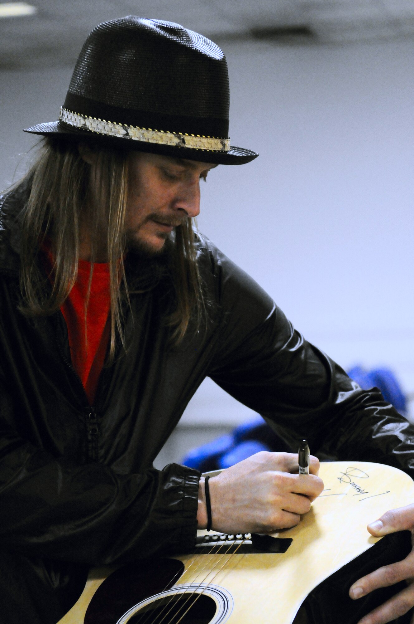 Kid Rock autographs an Airman's guitar while touring different units Nov. 30, 2009, at Incirlik Air Base, Turkey. Kid Rock and the Twisted Brown Truck Band, singer/songwriter Jessie James and comedian Carlos Mencia kicked off the tour making Incirlik their first stop to thank the troops. The three entertainers visited various places around the base including the 39th Security Forces Squadron, Incirlik’s American Forces Network studio and the 39th Force Support Squadron before putting on a free concert for members of the Incirlik community. (U.S. Air Force photo/Staff Sgt. Raymond Hoy)