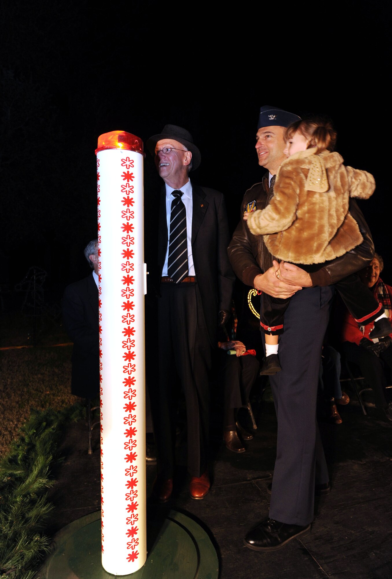 SUMTER, S.C. -- Colonel Joe Guastella, 20th Fighter Wing commander, and daughter, Anna, along with Sumter Mayor Joseph McElveen, observe The Fantasy of Lights just after flipping the switch Dec. 1. The Sumter community hosts a lighting ceremony annually at Swan Lake Iris Gardens where Airmen and Sumter residents participate in the lighting ceremony during the winter holidays. (U.S. Air Force photo/Tech. Sgt. Louis Rivers) 
