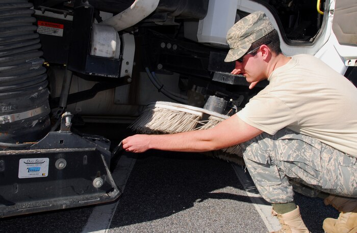 Airman Tyler Eubank inspects the undercarriage of a street sweeper before operating it along Hill Boulevard here Nov. 30. Airman Eubank is assigned the daily duty of ensuring Charleston AFB roadways and parking lots are kept clean of fall foliage and operates the sweeper on the flightline as well to remove dangerous gravel and foreign objects, averting their ingestion into aircraft engine intakes. Airman Eubank is a heavy equipment operator with the 437th Civil Engineer Squadron Operations Flight. (U.S. Air Force photo/Staff Sgt. Daniel Bowles)