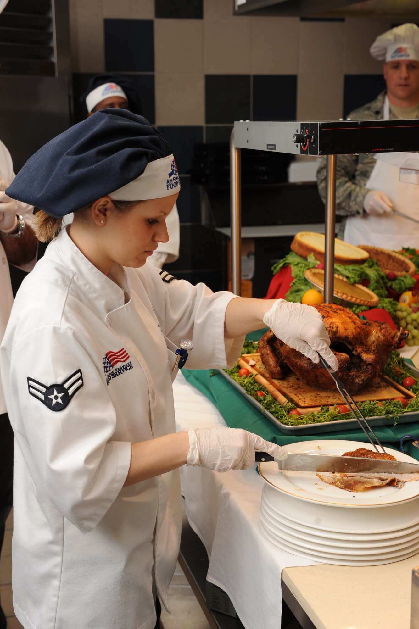 Airman 1st Class Staci Conrad, 19th Force Support Squadron food shift worker, slices turkey for base personnel during the Thanksgiving Day dinner Nov. 26 at the Hercules Dining Facility. Base leaders were also in attendance, serving Thanksgiving food to personnel and their families.