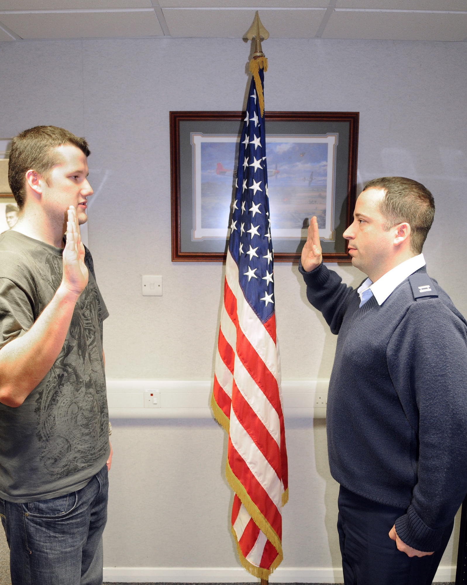 RAF MILDENHALL, England -- Daniel Coughlin (left) takes the oath of enlistment from Capt. Sidney Squires, 100th Force Support Squadron operations officer, at the Professional Development Center here Nov. 23. Daniel is a British-born American citizen who enlisted in the Air Force to become an aircraft hydraulics maintenance technician. He joins his brother, Joseph, as the third generation of his family to serve in the military. (U.S. Air Force photo/Senior Airman Thomas Trower)
