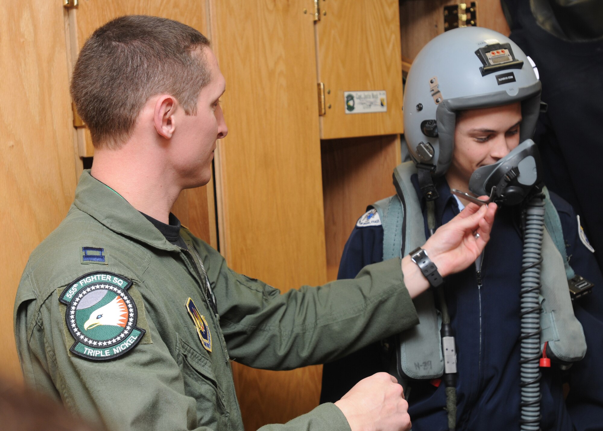 Capt. Craig Baker, 555th Fighter Squadron, assists Air Force Junior ROTC cadet Justen Smithers from the Aviano Air Base High School with putting on fighter pilot equipment Dec. 1, 2009 during a tour of Aviano Air Base, Italy.  Captain Baker is an F-16 fighter pilot and his unit is one of several on base who provide AFJROTC cadets an inside look at a variety of different career fields the Air Force offers.  (U.S. Air Force photo/Airman LaVel Sterling)
