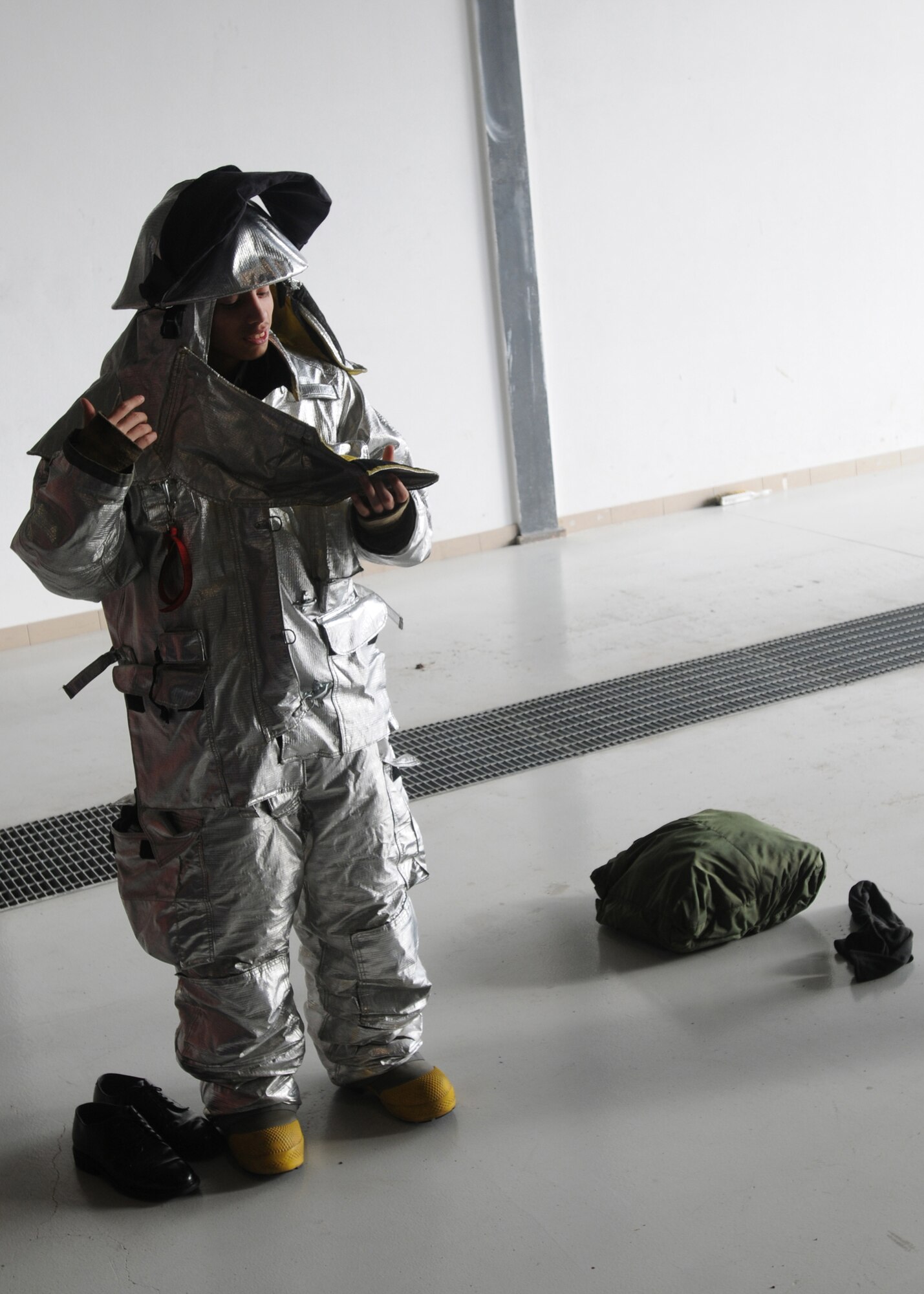 Michael Mendoza, an Air Force Junior ROTC cadet from Aviano Air Base High School suits-up in a firefighter ensemble Dec. 01, 2009 during a tour of Aviano Air Base, Italy.  The 31st Civil Engineer Squadron?s fire department is one of several stops on the annual AFJROTC base tour here giving cadets an inside look at a variety of different career fields the Air Force offers.  When fully suited up, a firefighter ensemble plus oxygen tanks which are carried on the back, weighs approximately 75 pounds. (U.S. Air Force photo/Airman LaVel Sterling)