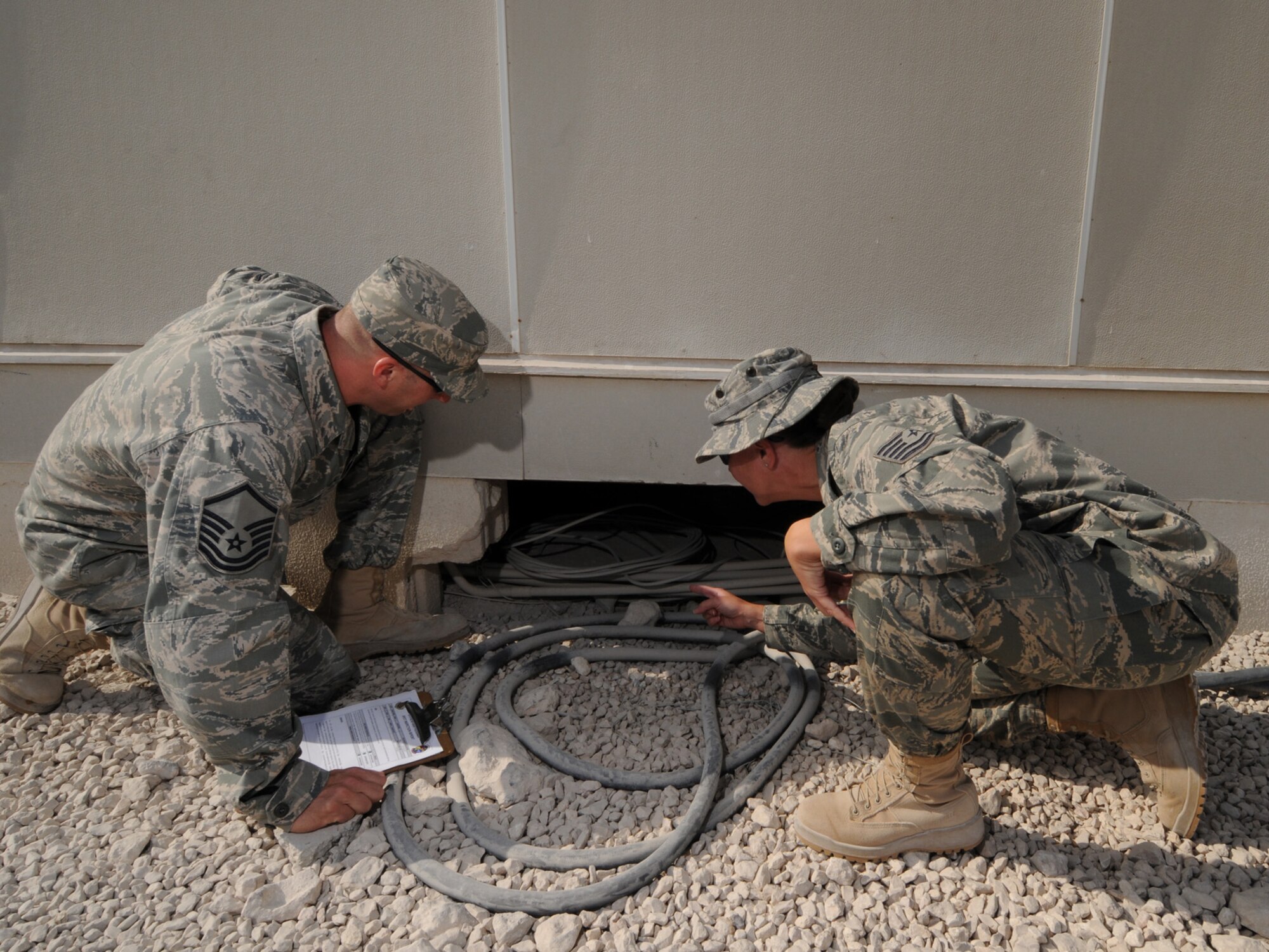 Left, Master Sgt. Kevin Jones, 379th Air Expeditionary Wing Force Protection NCOIC, conducts a random anti-terrorism measure spot inspection with Tech. Sgt. April Coleman, 379 AEW Area Defense Counsil defense paralegal, Dec. 2, 2009. The 379 AEW Force Protection office coordinates installation-wide efforts to reduce the vulnerability of deployed personnel and resources throughout the base. (U.S. Air Force Photo/Tech. Sgt. Jason W. Edwards)