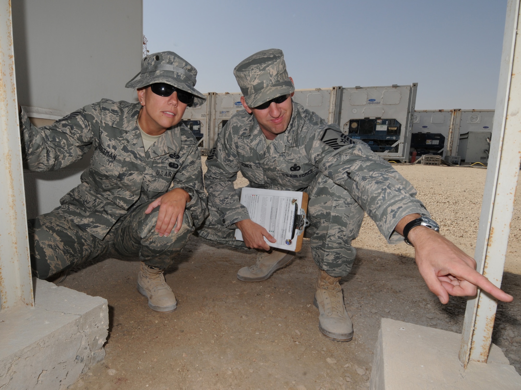 Right, Master Sgt. Kevin Jones, 379th Air Expeditionary Wing Force Protection NCOIC, conducts a random anti-terrorism measure spot inspection with Tech. Sgt. April Coleman, 379 AEW Area Defense Counsil defense paralegal, Dec. 2, 2009. The 379 AEW Force Protection office coordinates installation-wide efforts to reduce the vulnerability of deployed personnel and resources throughout the base. (U.S. Air Force Photo/Tech. Sgt. Jason W. Edwards)