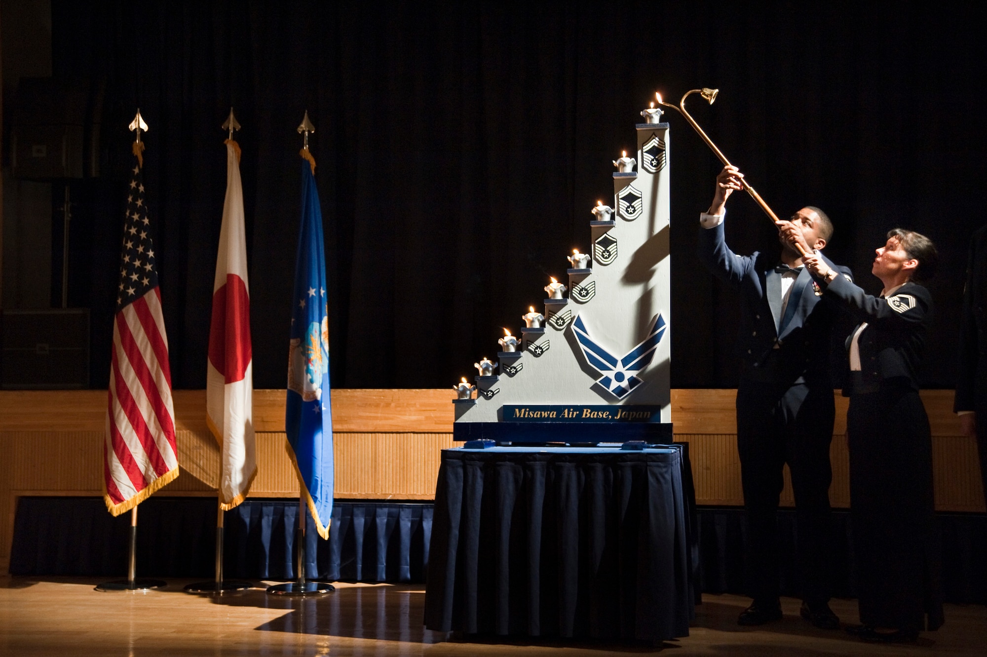MISAWA AIR BASE, Japan -- Misawa Air Base's newest chief master sergeants, Chief Master Sgts. Phillip Easton and Suzanne Talbert, light the chief master sergeant candle during the Chiefs' Recognition Ceremony Dec. 1 at the Collocated Club. This date holds special significance because it was Dec. 1, 1959, when the first 625 chief master sergeants, called "Charter Chiefs," were promoted to the new rank created under the Career Compensation Act of 1958. (U.S. Air Force photo/Staff Sgt. Samuel Morse)