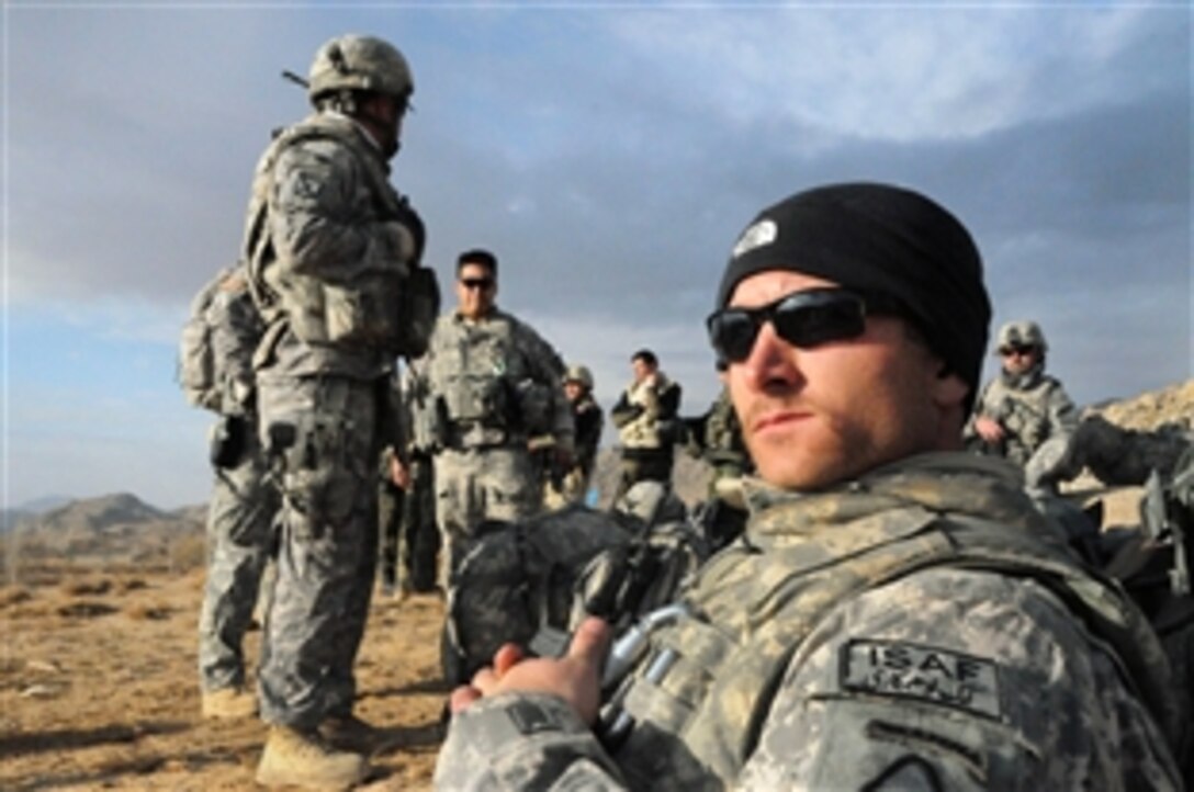 U.S. Army Staff Sgt. Shawn Kruse and other members of the Provincial Reconstruction Team Ghazni wait for a helicopter in Jaghori, Afghanistan, Nov. 30, 2009. Members of the Ghazni team visited Jaghori to perform quality control on several team projects. Kruse, a member of the International Security Assistance Force, is assigned to Forward Operating Base Ghazni.