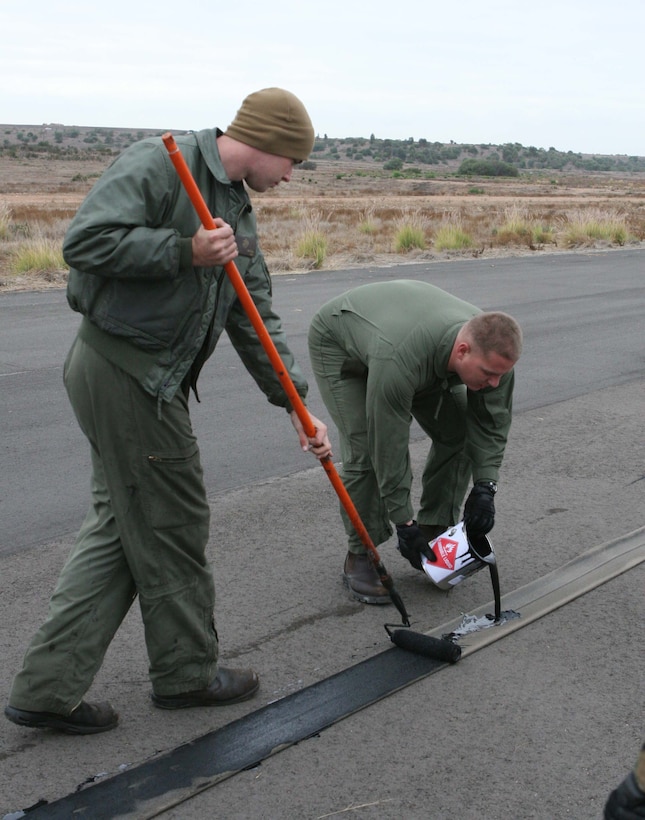 Expeditionary Airfield Systems Technicians apply a protective coating to the tape on E-28 arresting gear, which is used to stop aircraft on the flightline during emergency landings. The Marines worked hard to prepare for the annual inspection and certification of the gear Dec. 2-4.
