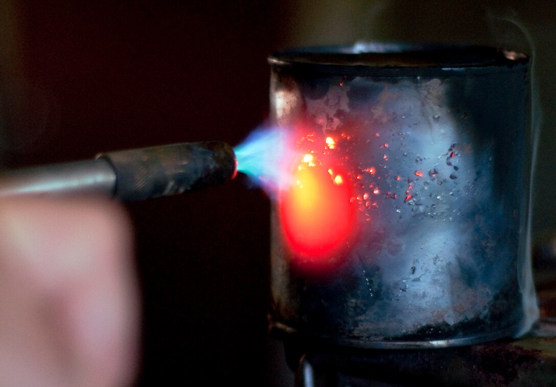 Using a blowtorch, Sgt. William W. Patnode, Headquarters Battalion, Chemical Biological Radiological Nuclear chief, activates o-Chlorobenzylidene Malononitrile gas, more commonly known as CS gas, during a Field Protective Mask Confidence Exercise using the newly issued M50 Joint Service General Purpose gas masks at the base gas chamber Dec. 2.