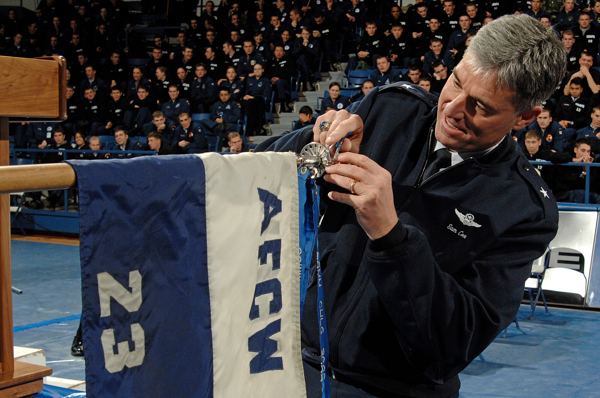 Brig. Gen. Samuel Cox affixes the Commandant's Challenge 2009 Champion streamer to Cadet Squadron 23's guidon at the conclusion of the challenge Nov. 24, 2009. The win is the second in a row for CS23. General Cox is the commandant of cadets. (U.S. Air Force photo/Mike Kaplan)